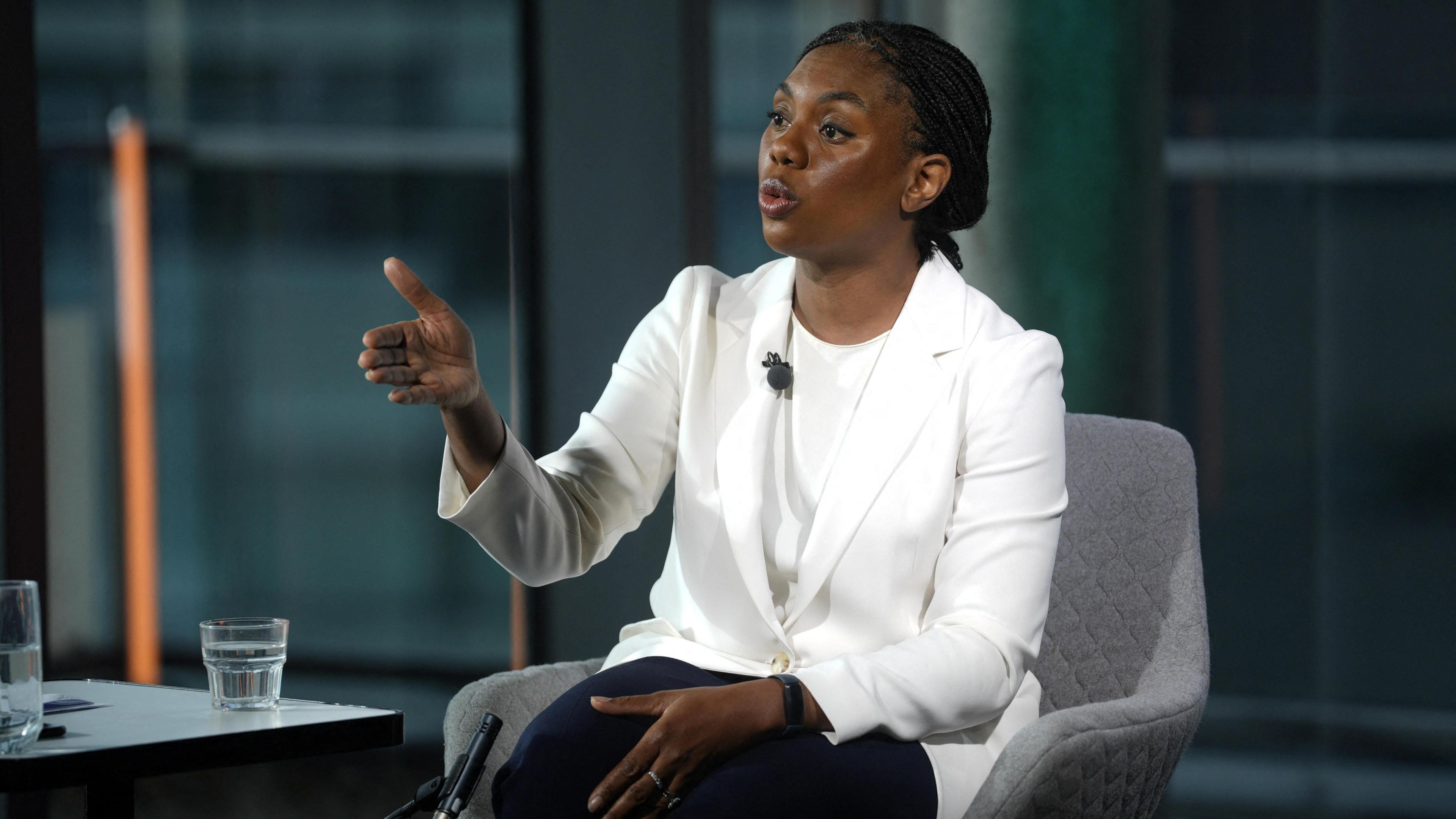 Kemi Badenoch wearing a white jacket and t-shirt