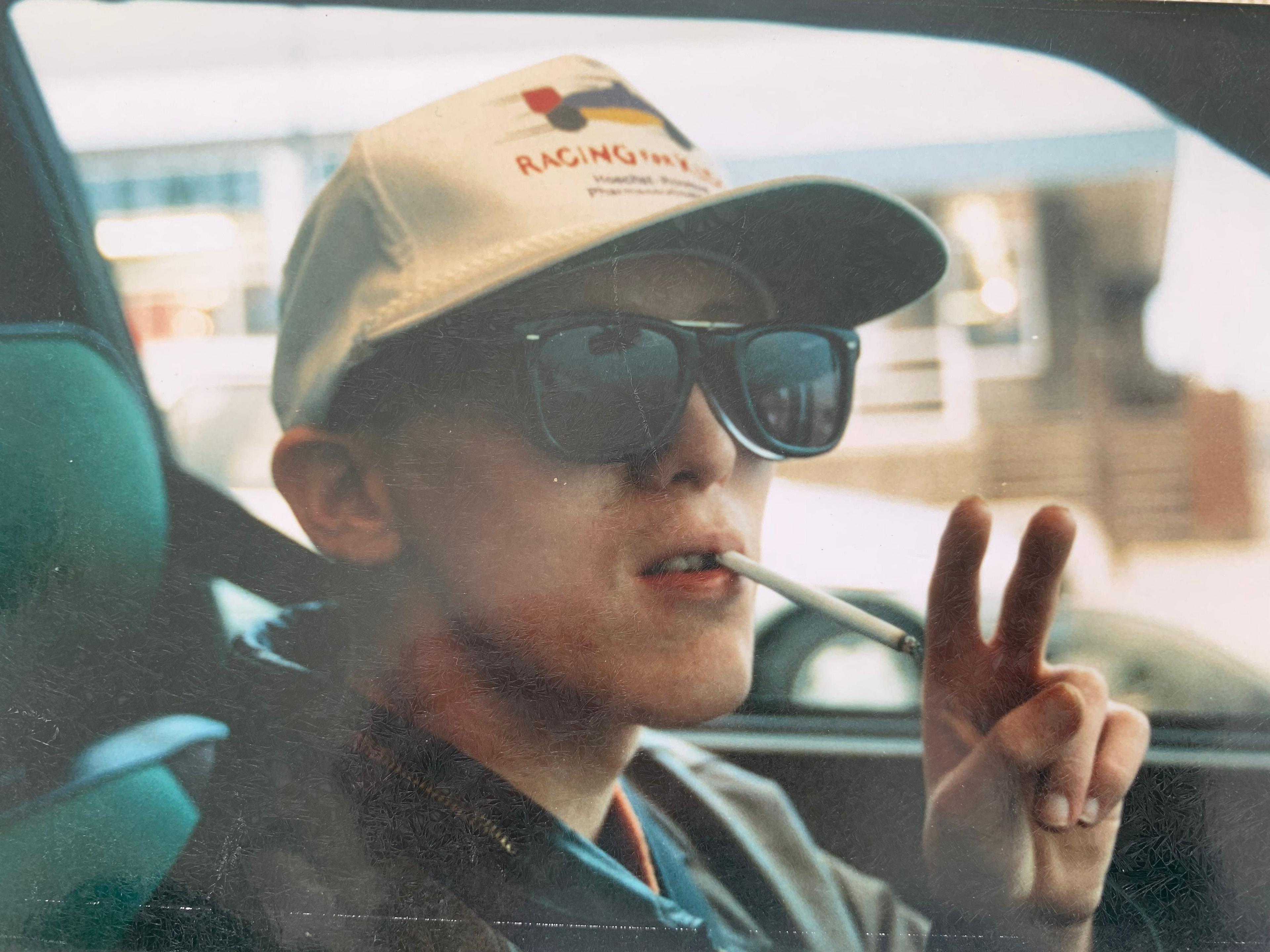 Young man in cap and sunglasses smoking