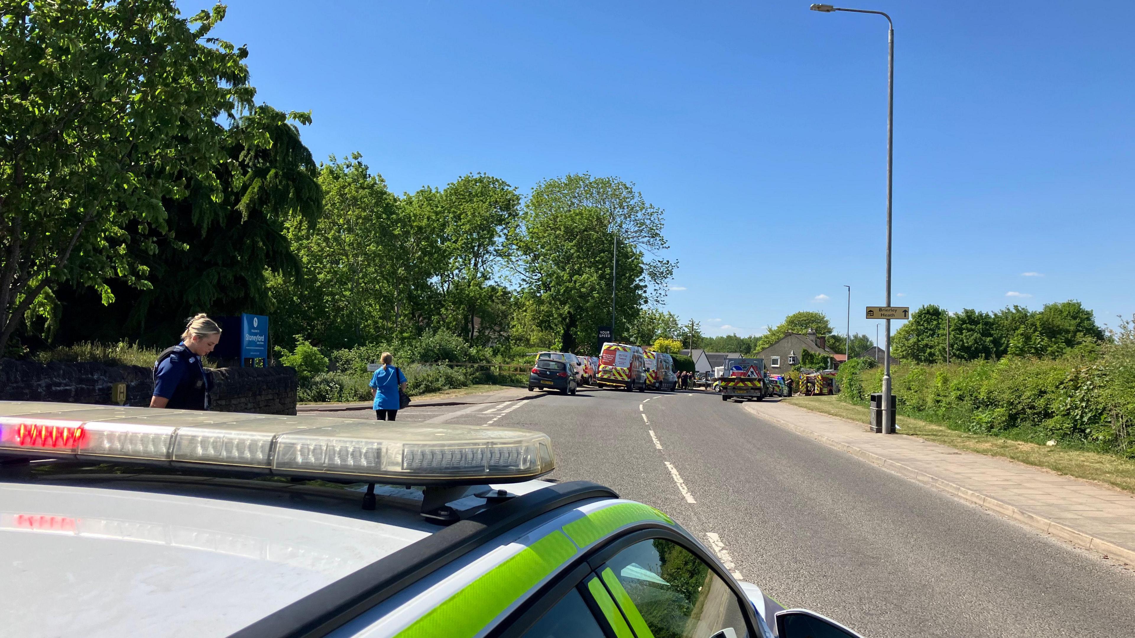 A police car and Cadent vehicles in the road