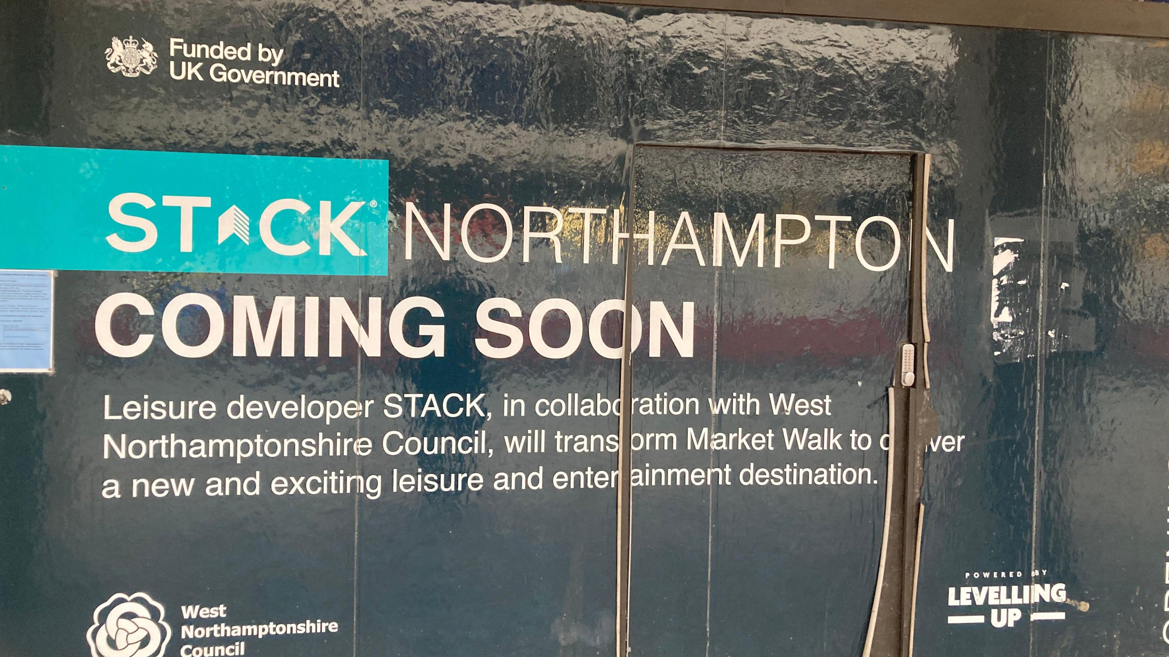 A black sign stating the future location of STACK - a entertainment venue in Northampton.