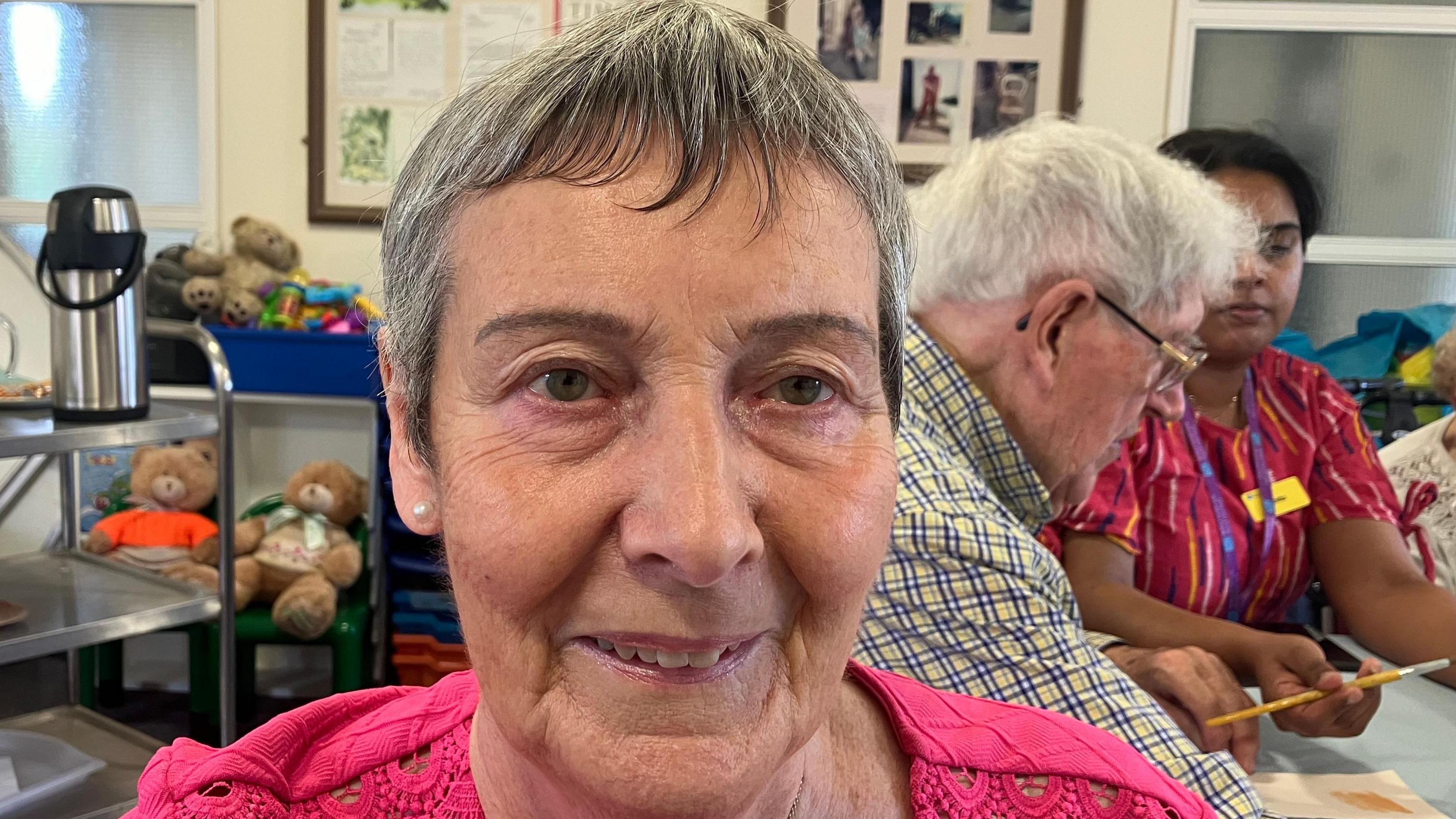 A woman in an art class smiling at the camera