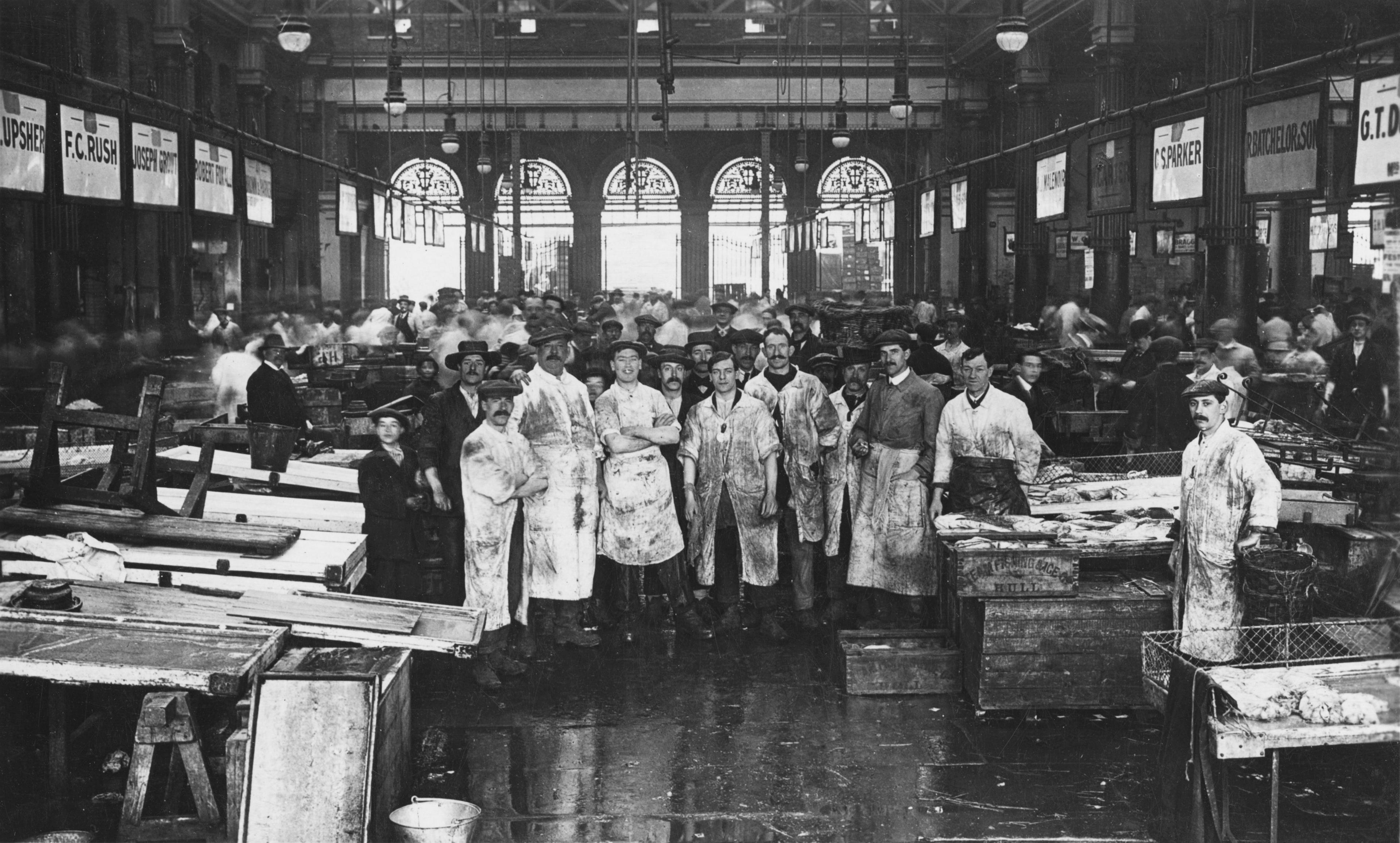 Black and white image of dozens workers in Billingsgate Fish Market