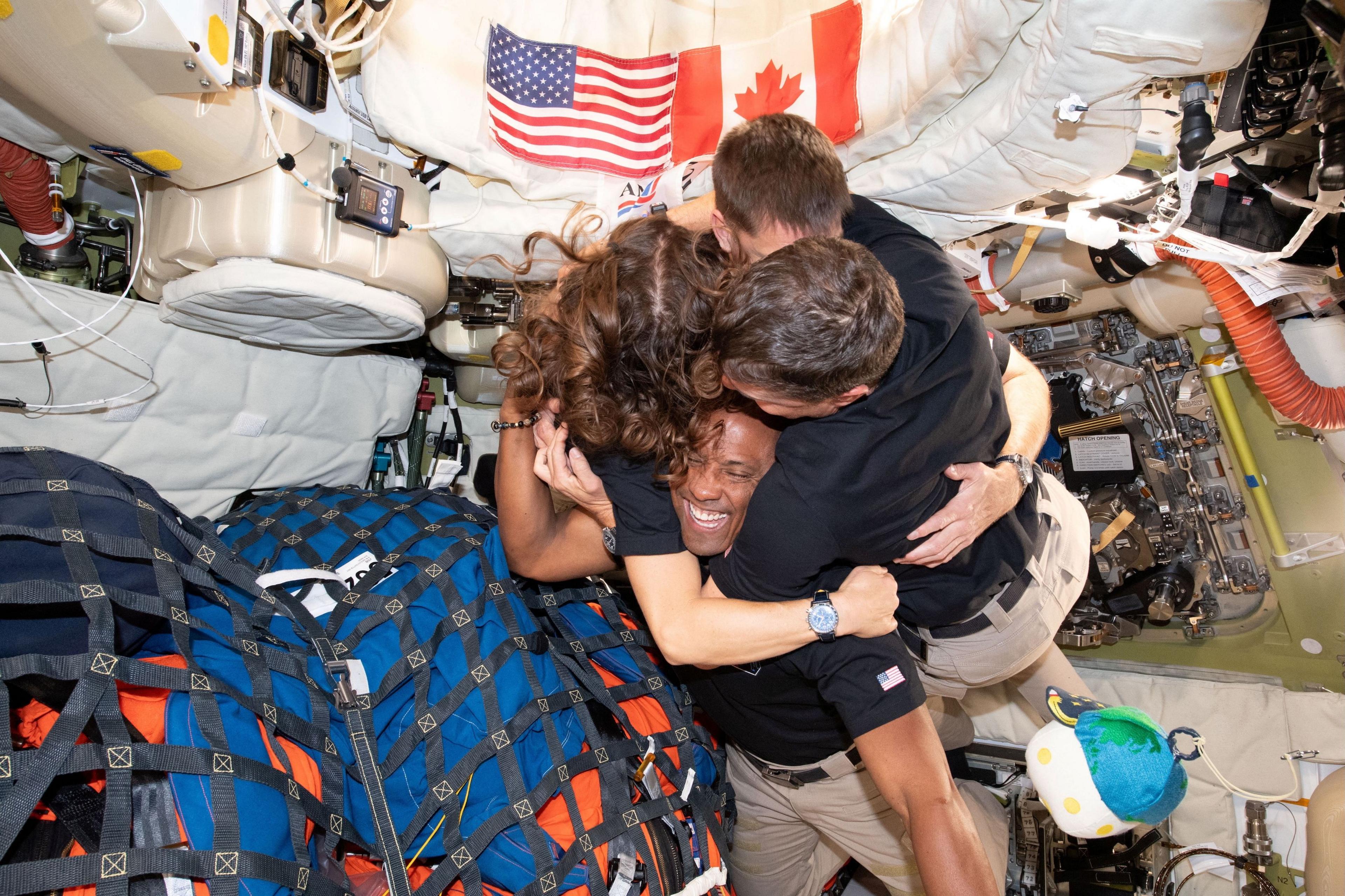 the Orion crew all hugging on board