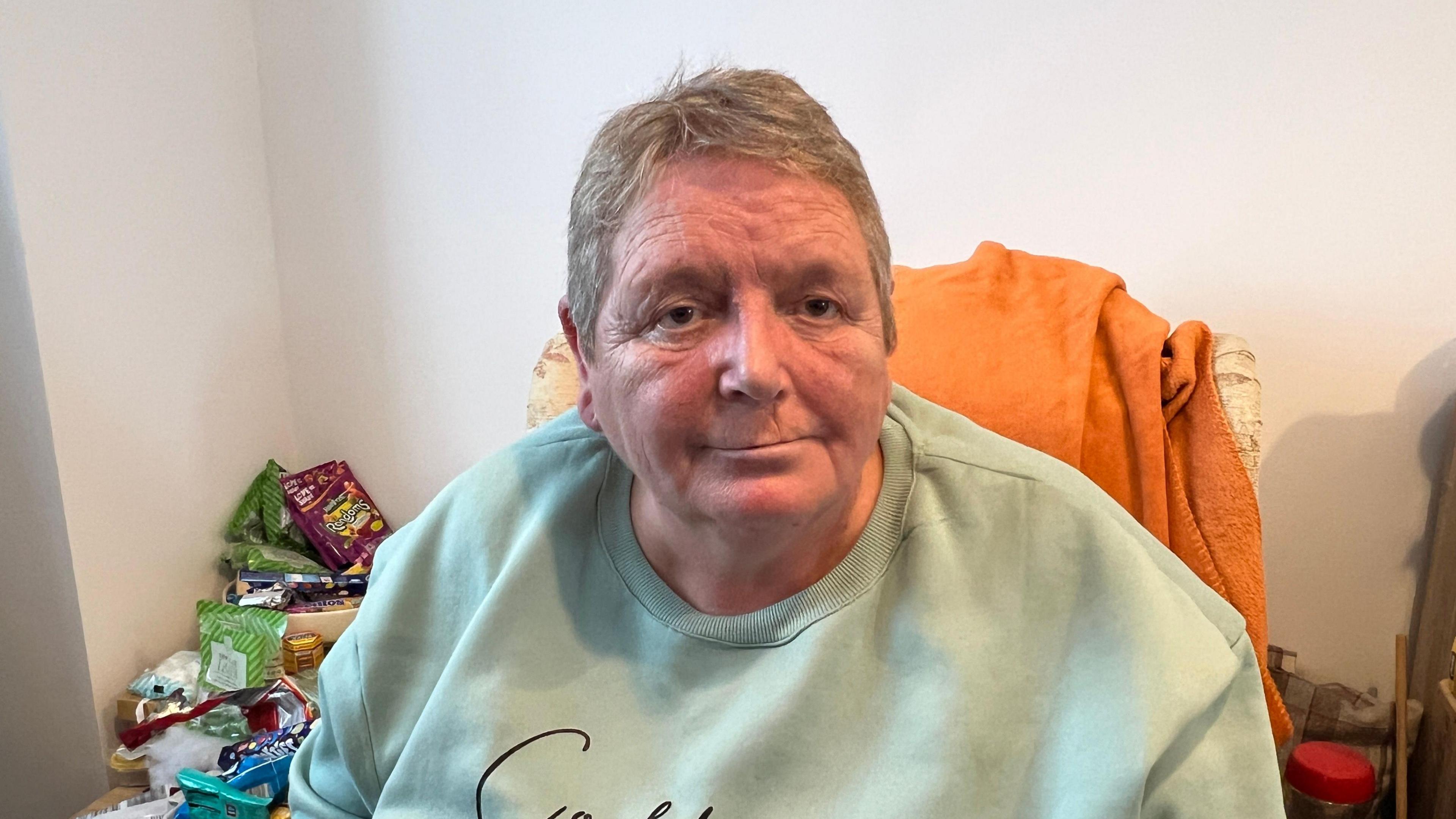 Diane Pickup is looking straight at the camera. She has short, fair hair and is wearing a green jumper.