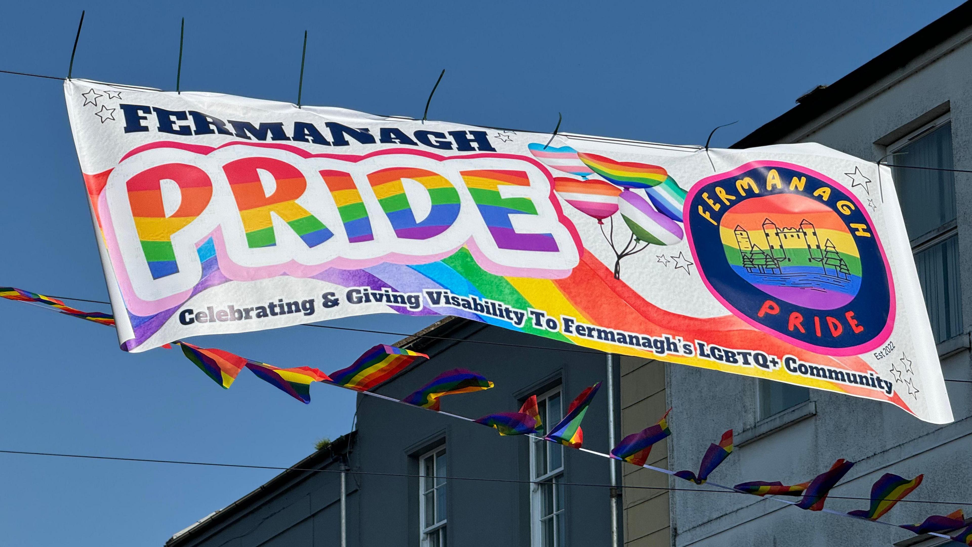 A sign saying Fermanagh Pride. Celebrating and giving visibility to Fermanagh's LGBTQ+ community. The text is displayed in rainbow colours.