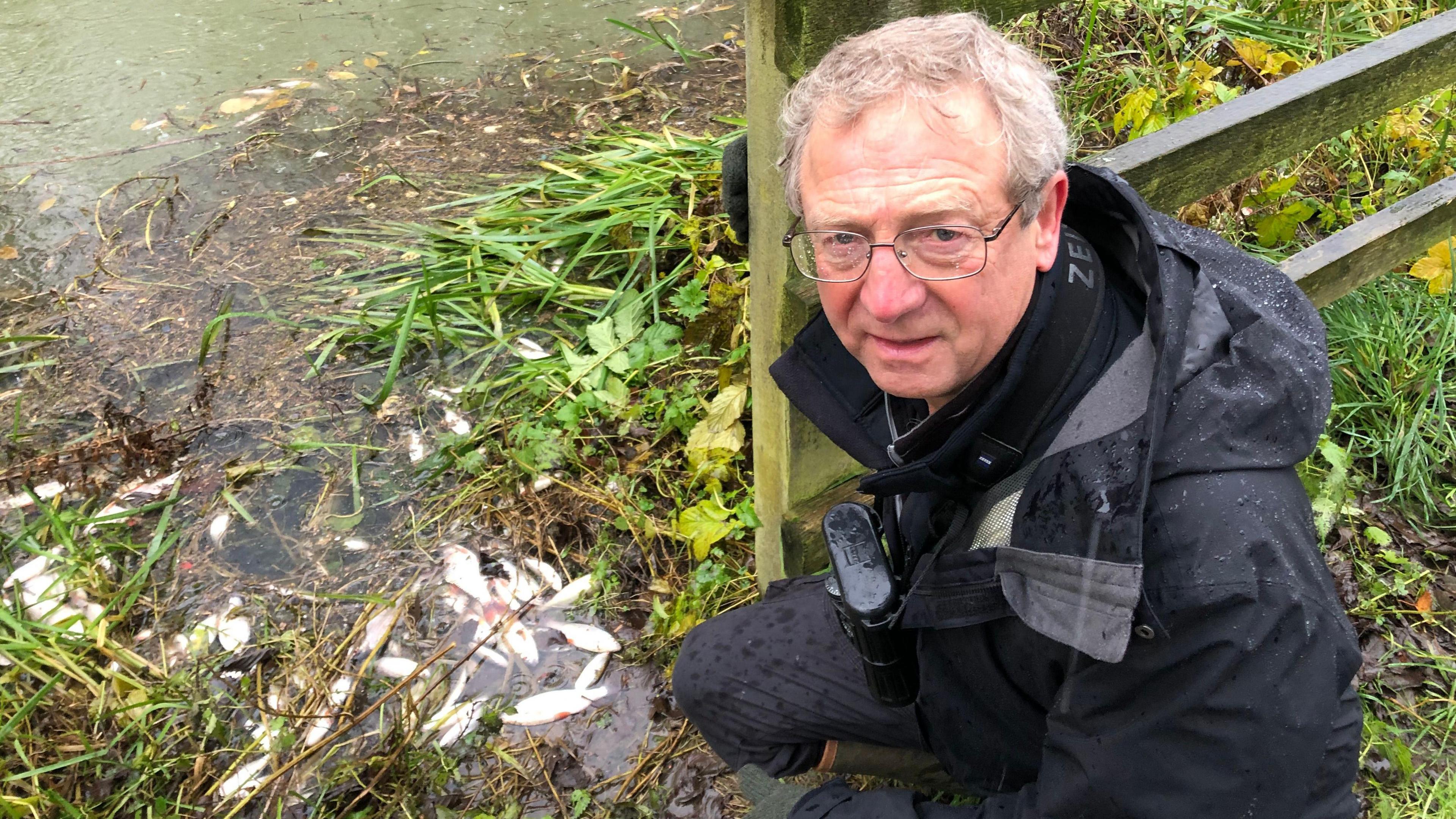 Chris Park on the river bank with dead fish 