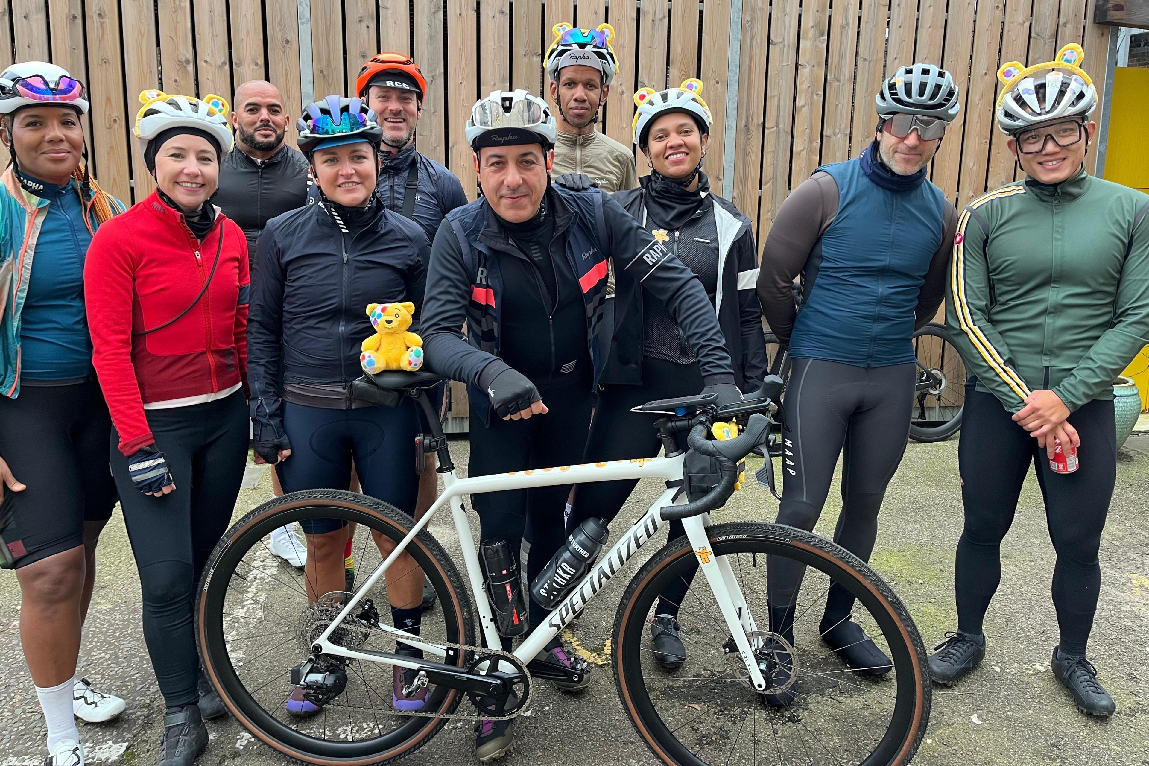 Nico Georgiou (centre) leans on his bike with Pudsey bear on the saddle alongside nine other cyclists, some of whom are wearing Pudsey ears