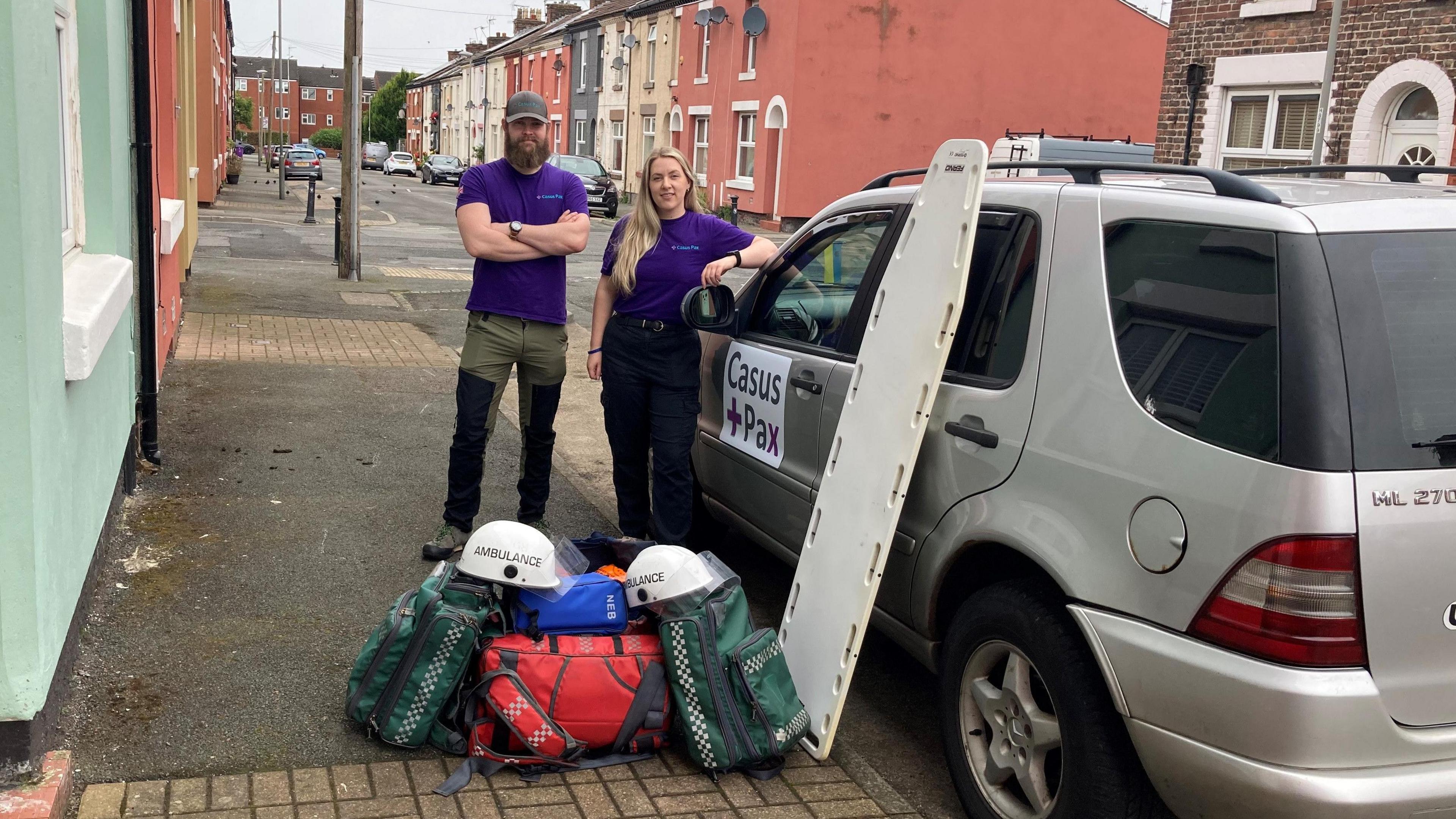 Adam McQuire and Holly Tann standing by their car 