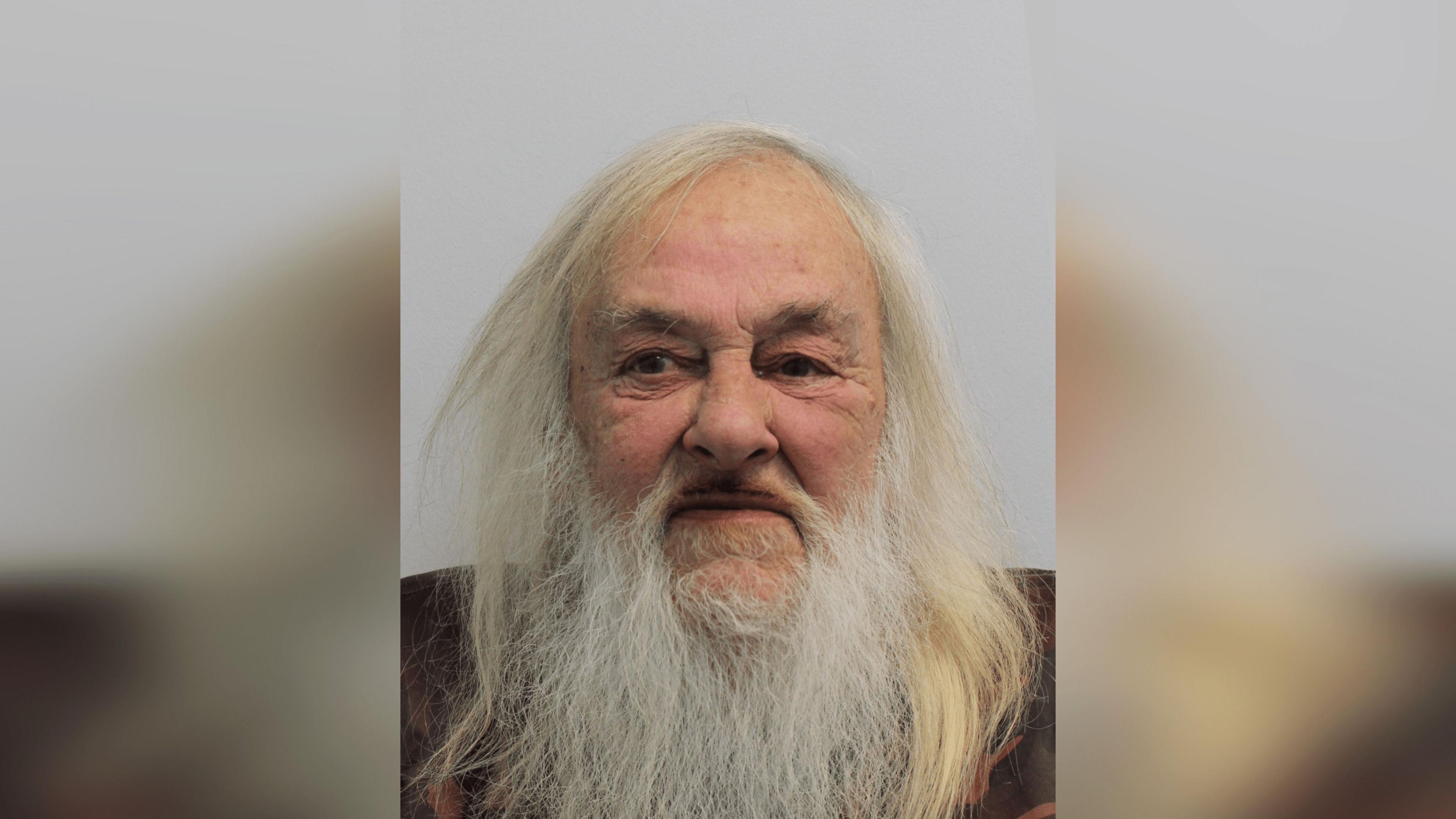 A custody image of David Cheneler. He has long white hair and a white beard.