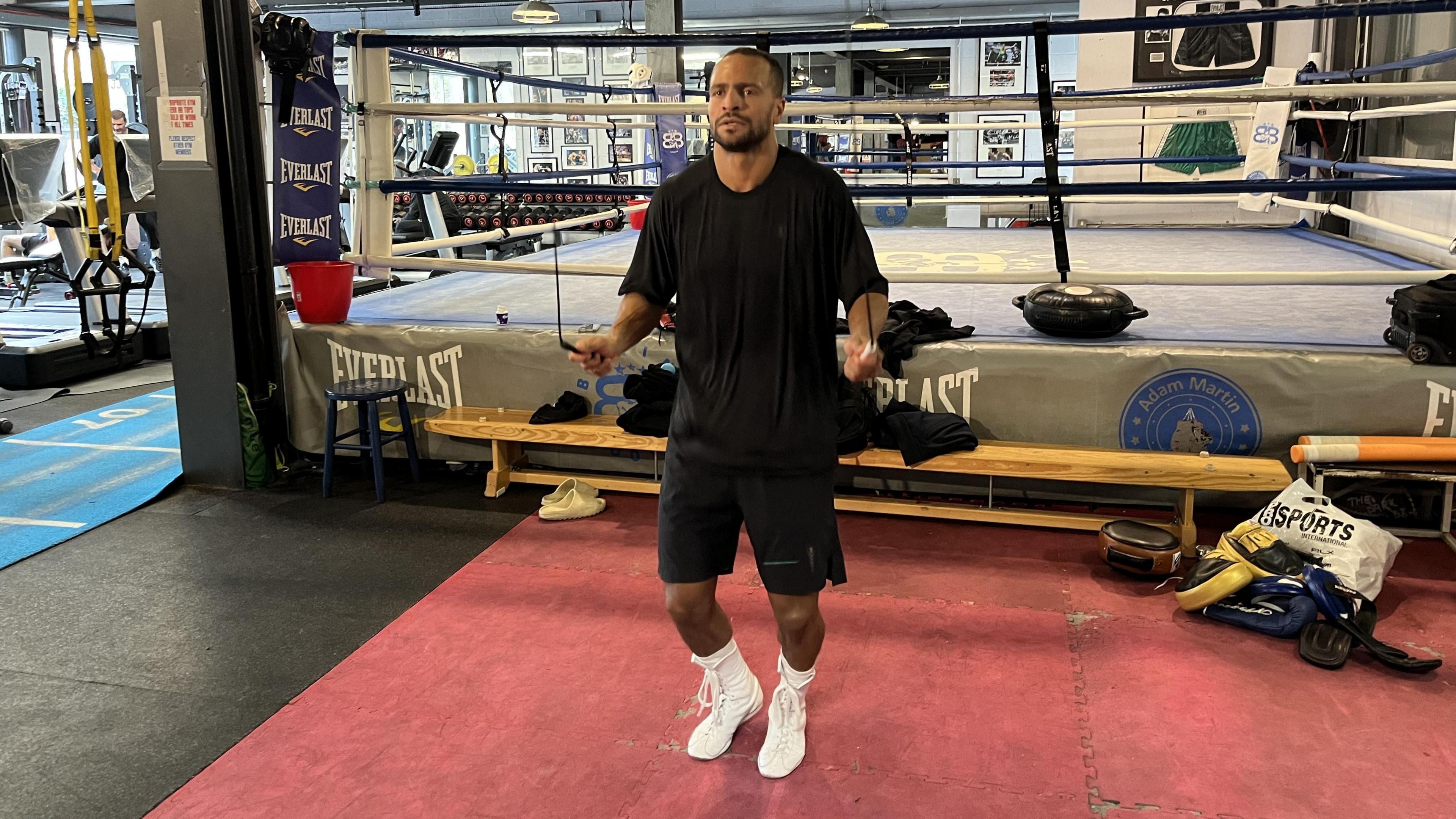 Harlem Eubank in a gym wearing a black t-shirt and shorts skipping.