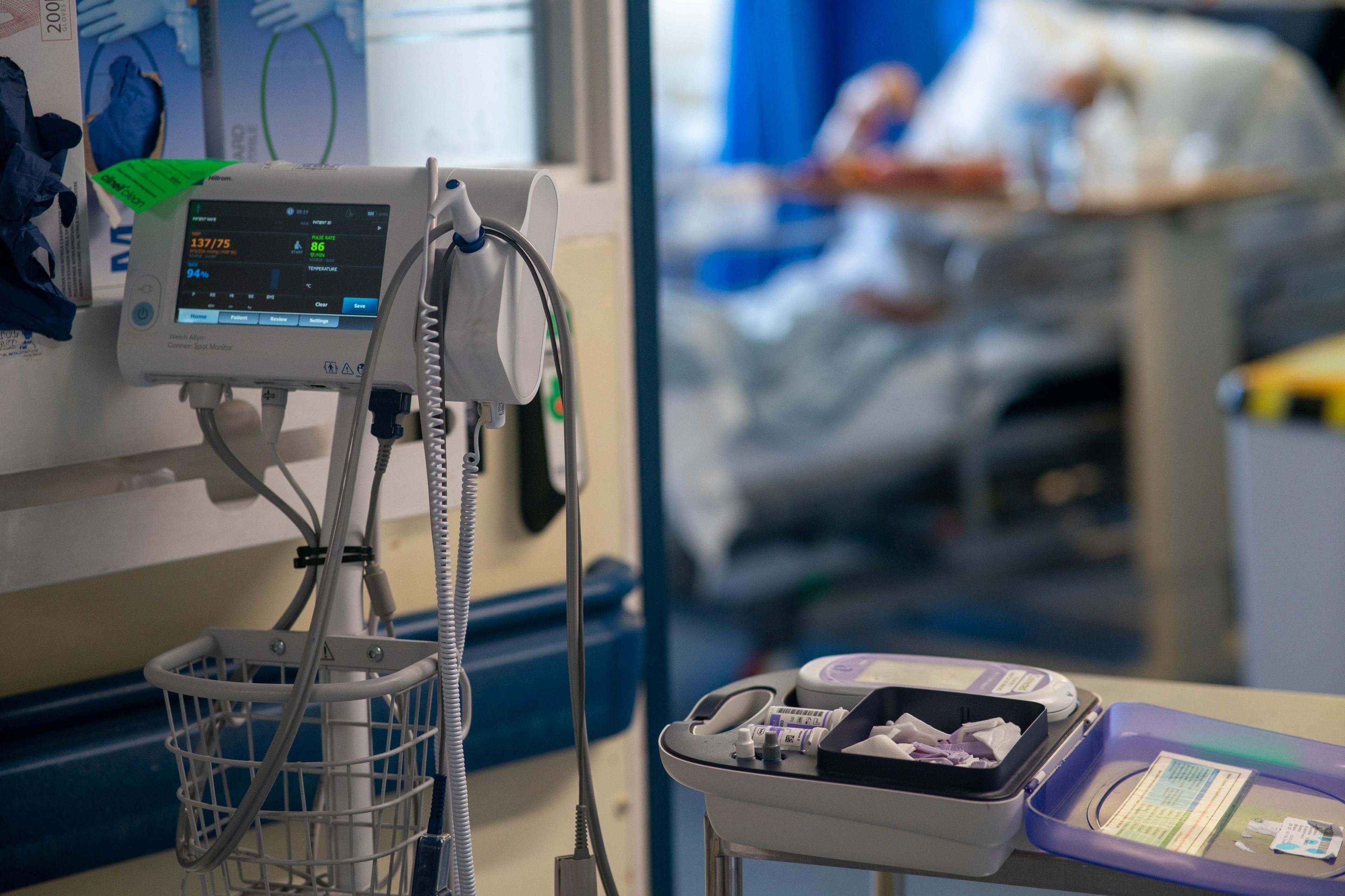 Hospital equipment with a blurred patient in the background