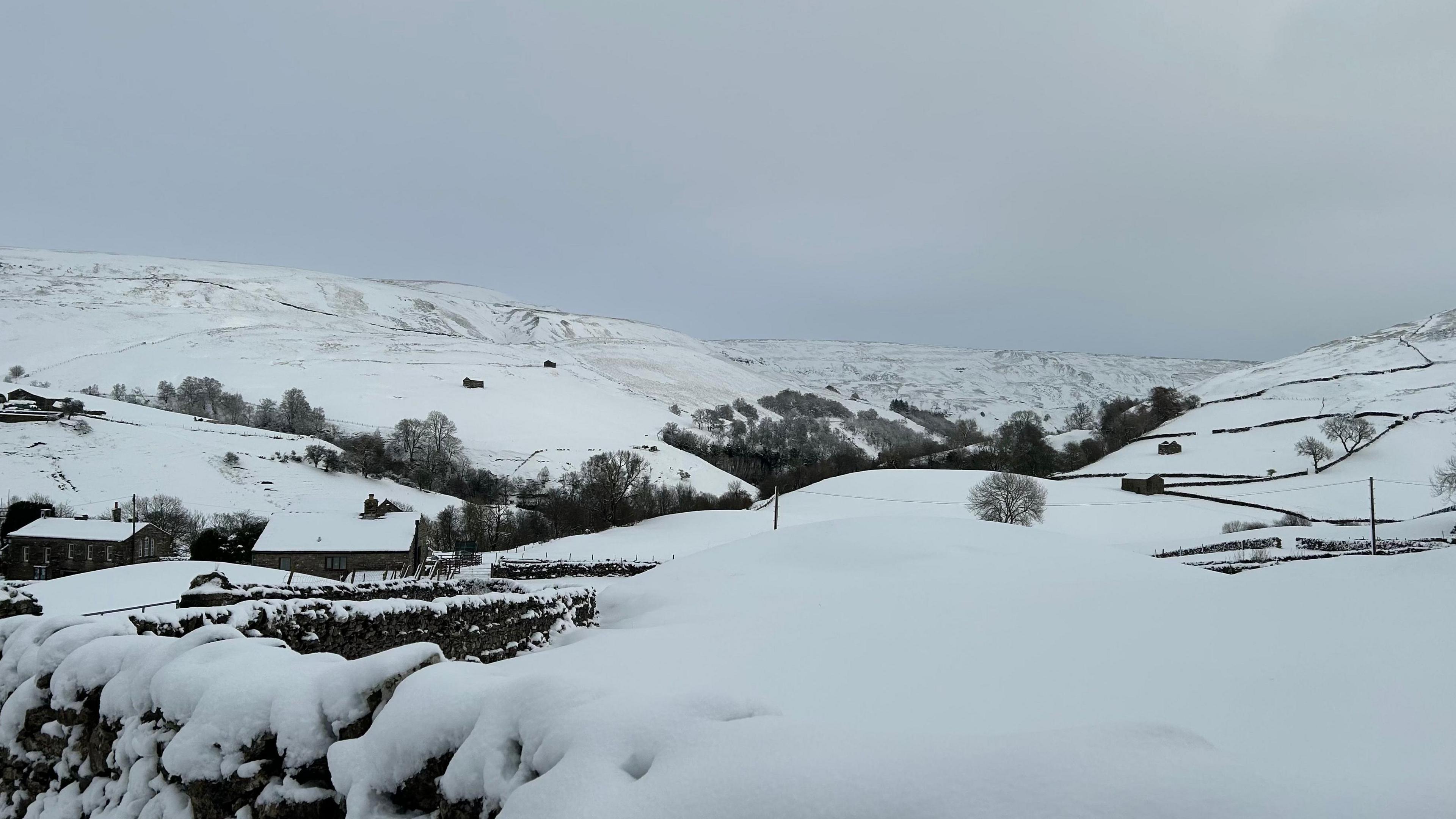 A very snowy image of the Yorkshire Dales with a grey sky above.