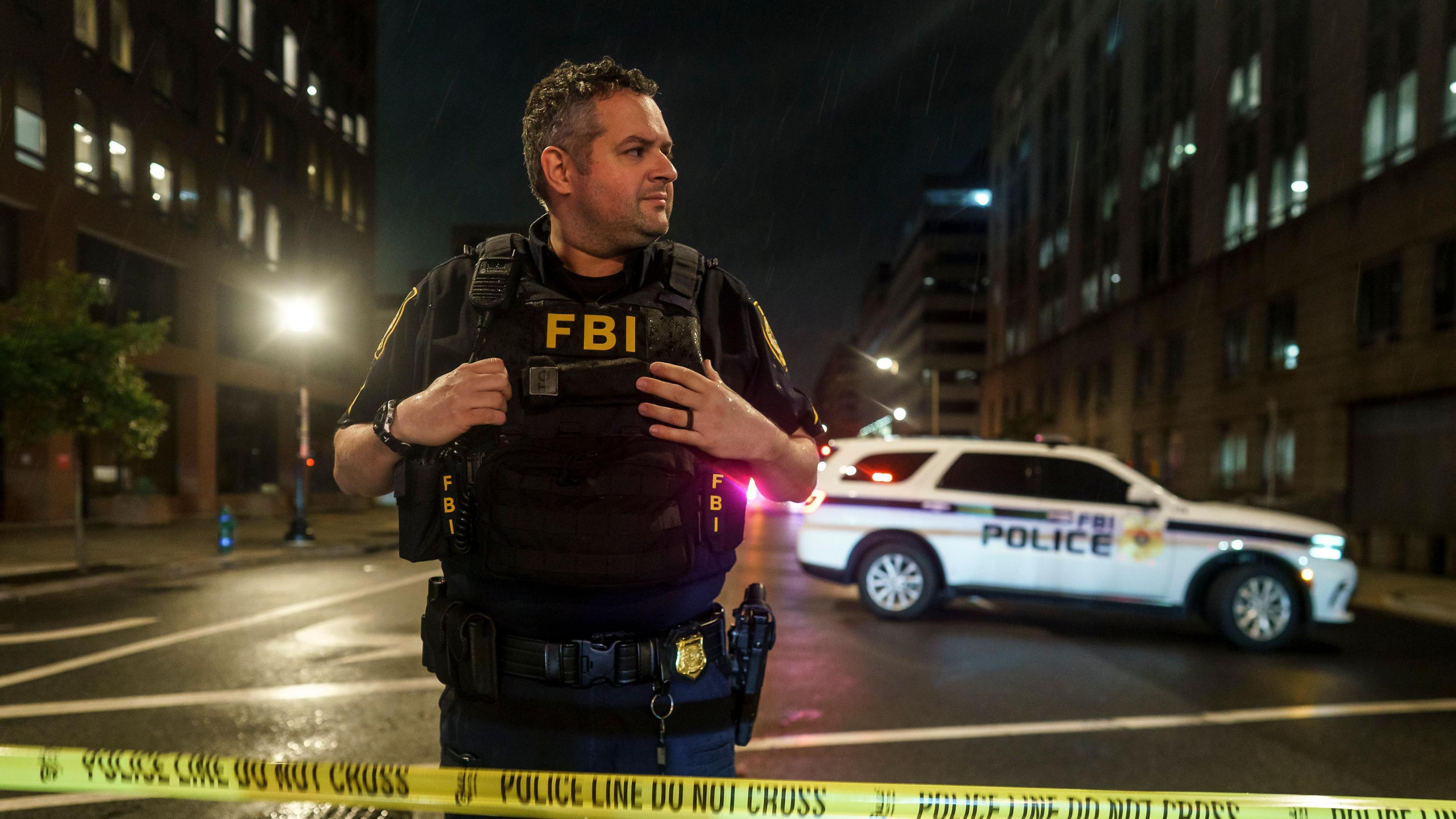 A FBI agent stands at a police cordon