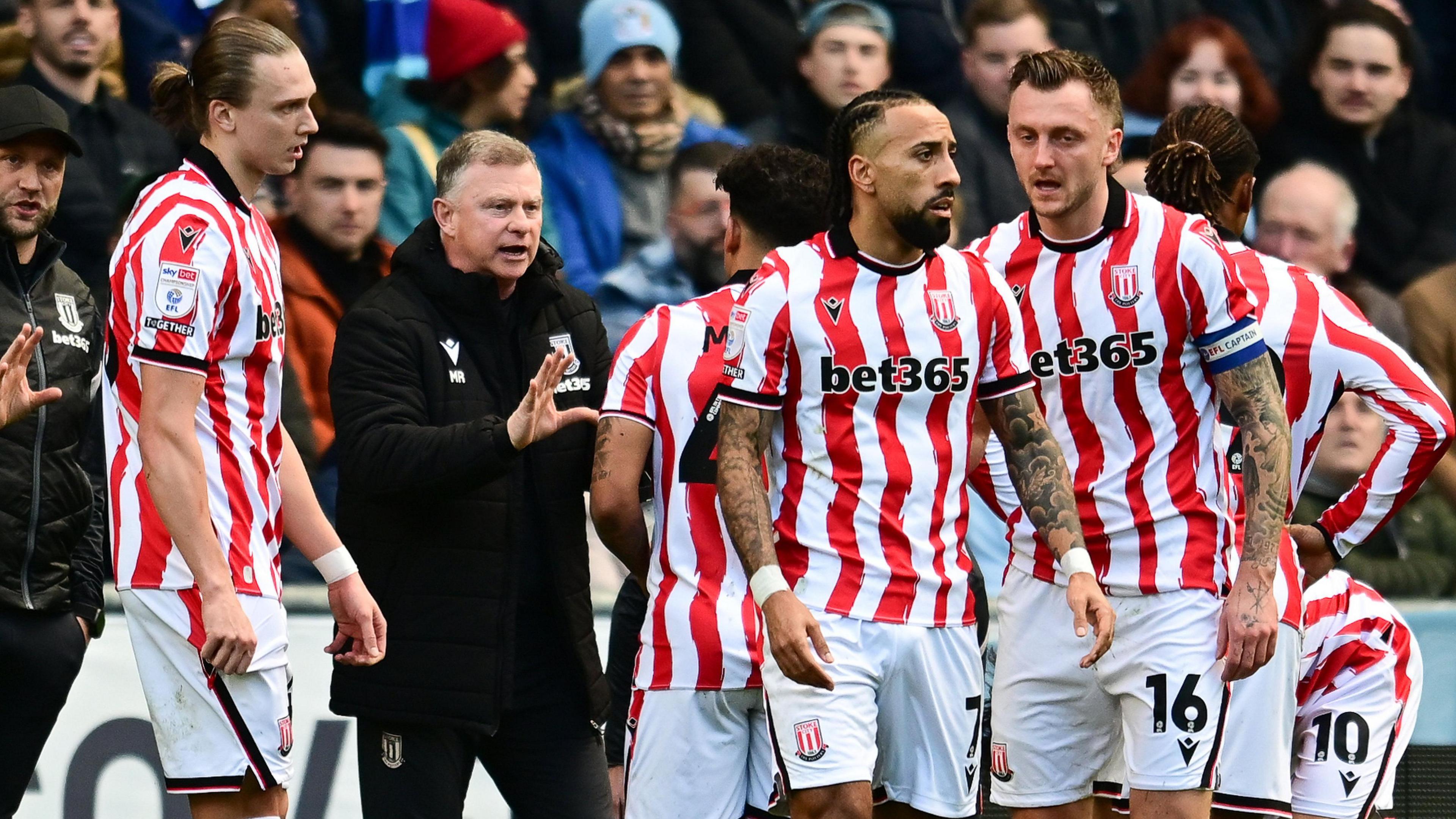 Mark Robins issues instructions to Stoke City players on the touchline during a game