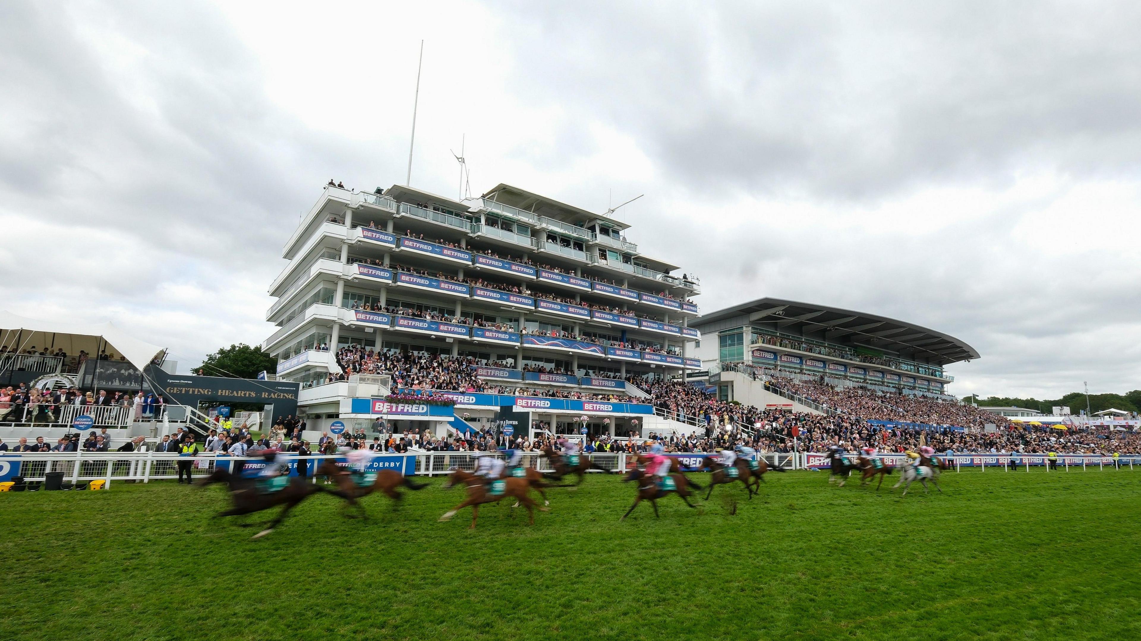 A general view as runners pass the winning post during The Aston Martin 'Dash' Handicap on Derby Day during the Derby Festival at Epsom Downs Racecourse on June 01, 2024 in Epsom, England.
