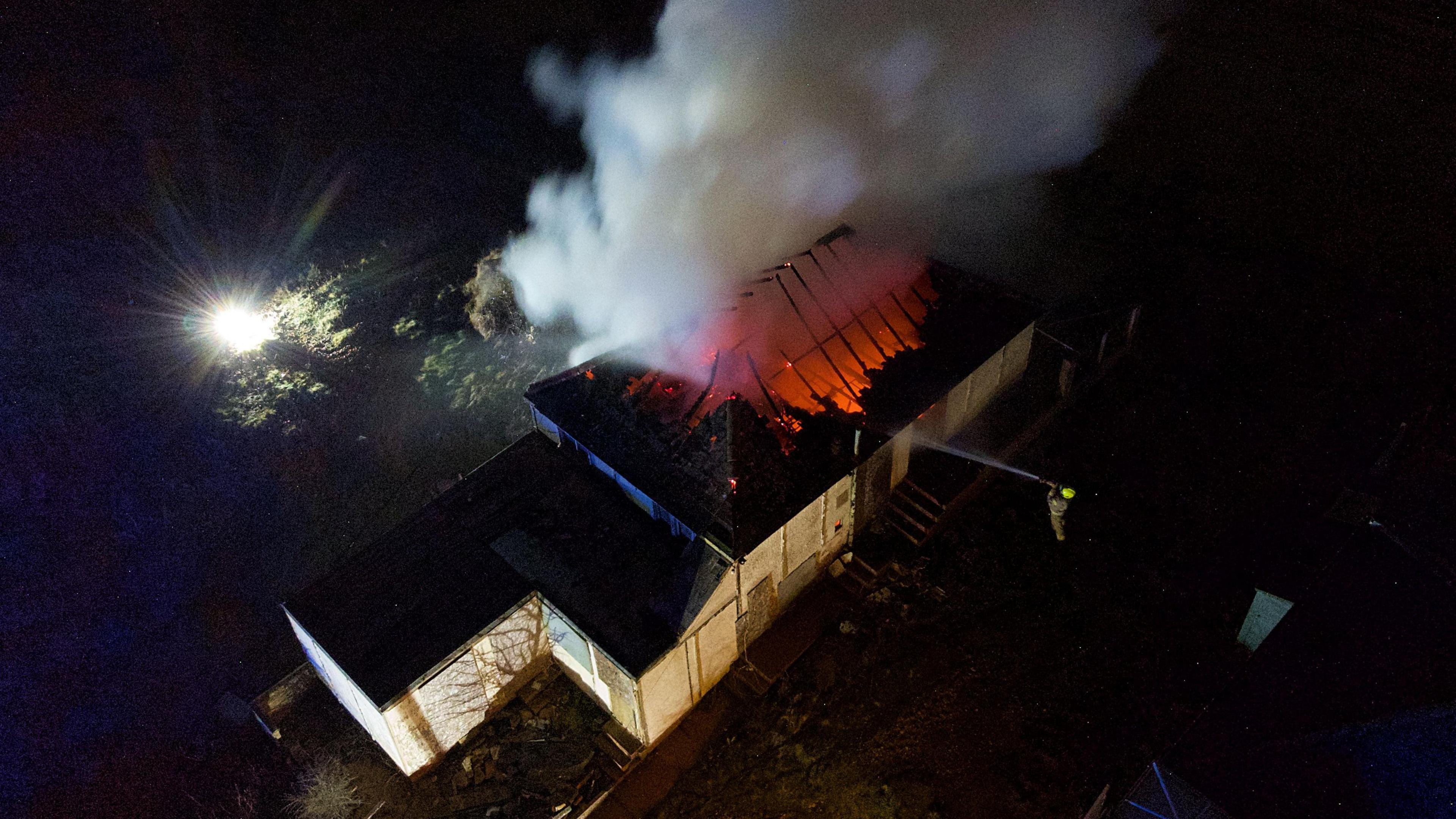 The roof of a derelict house on fire