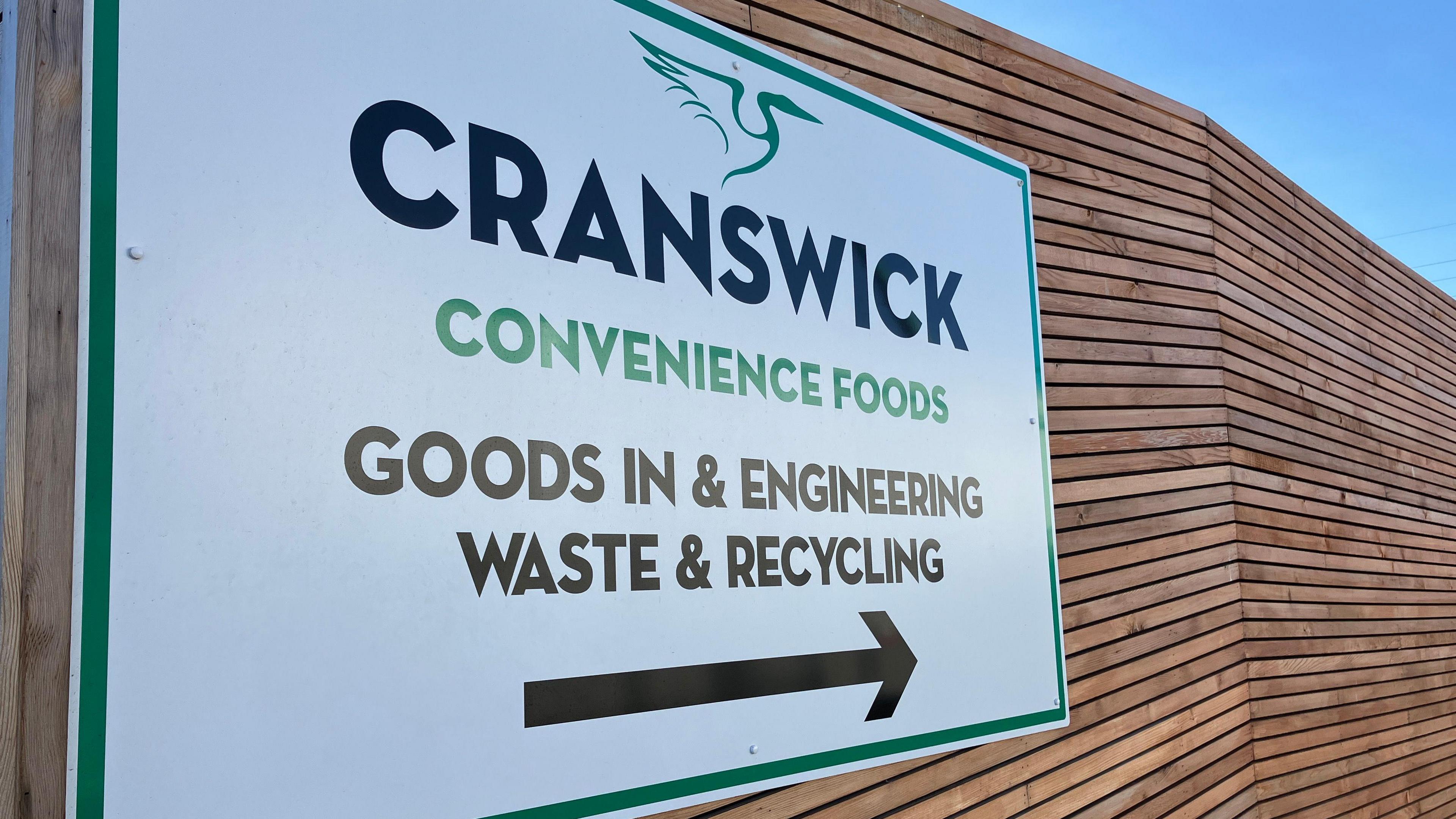 A close-up of a sign at the entrance to the factory. It bears the company emblem and the words "Cranswick Convenience Foods"