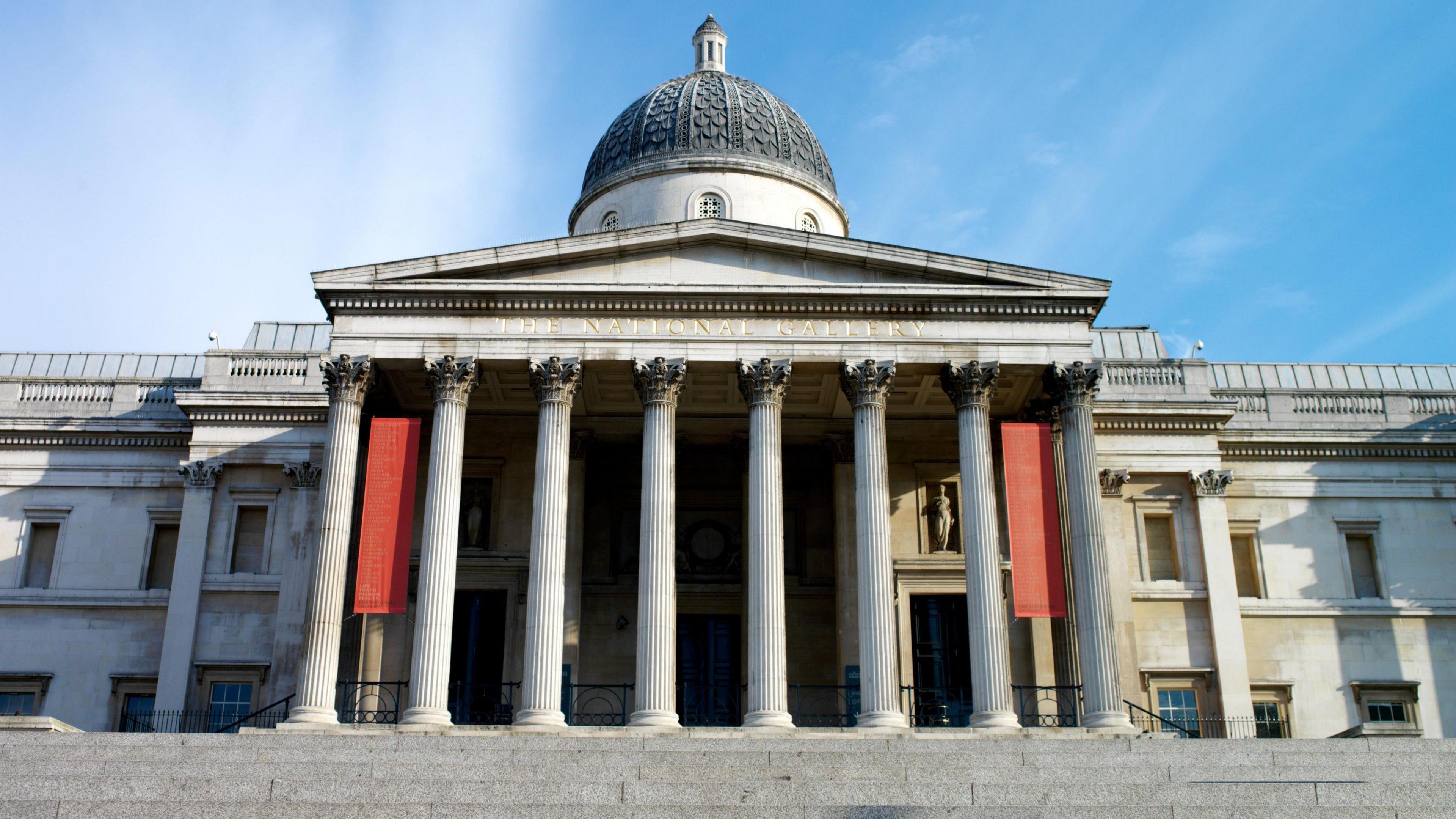 A stock photo of the National Gallery in Trafalgar Square. The view is from the bottom of the stairs, as if the cameraman is looking up at the building. There are no people in the picture. 