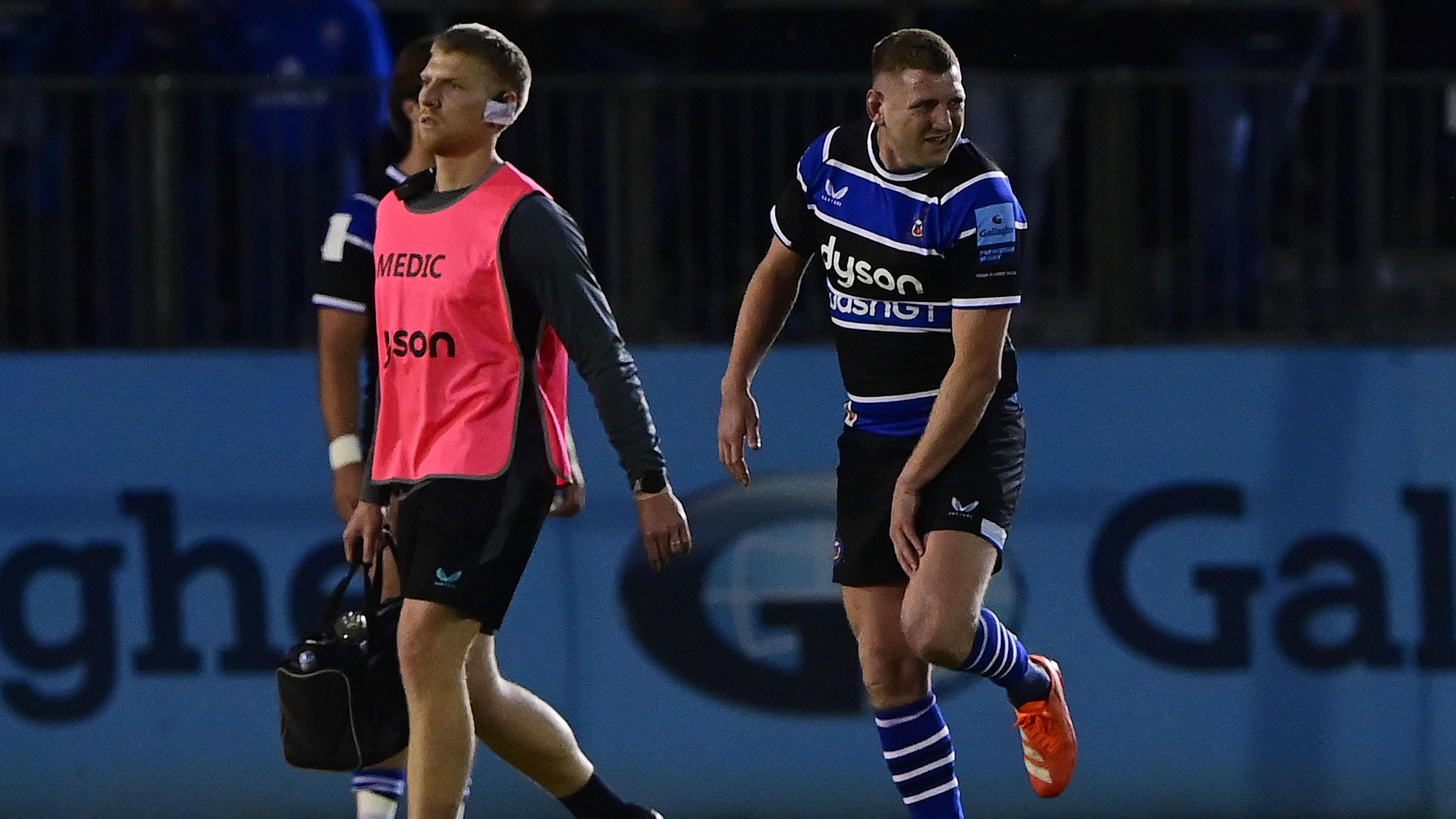 Finn Russell (right) holds his leg as he walks off the pitch