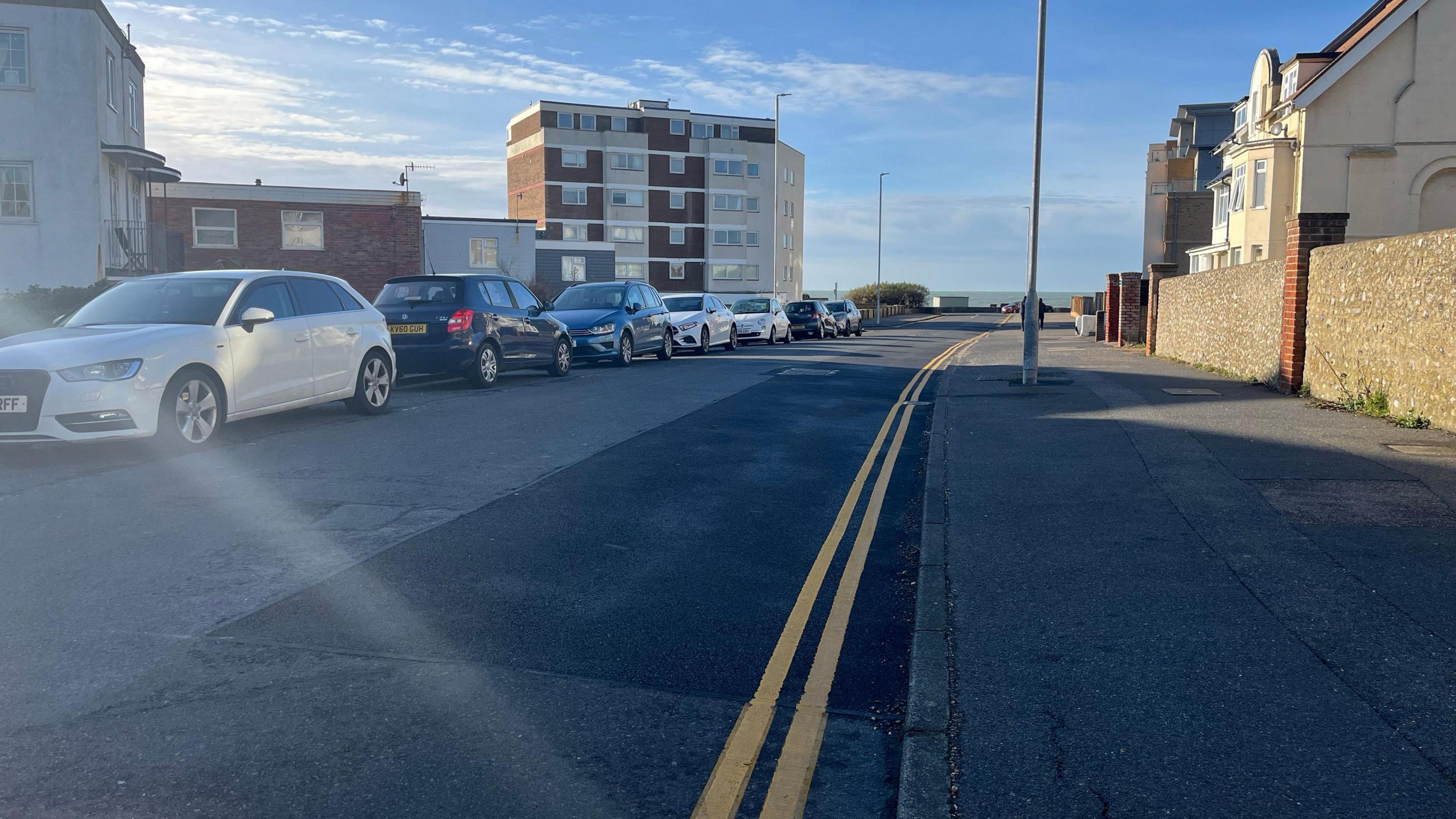 A repaired section of road with freshly painted double yellow lines on Dane Road in Seaford