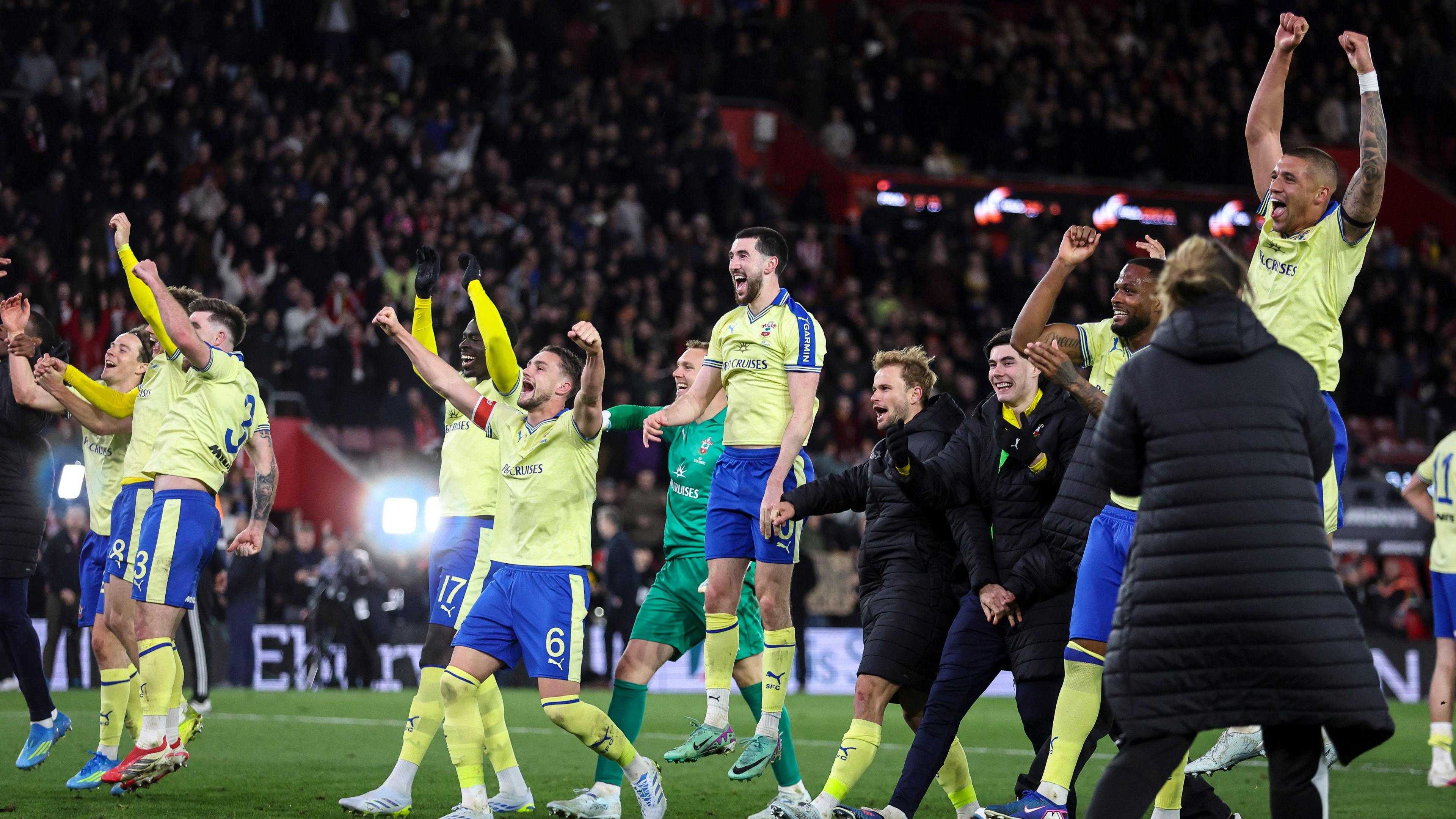 Southampton players celebrate, with arms raised and leaping into the air