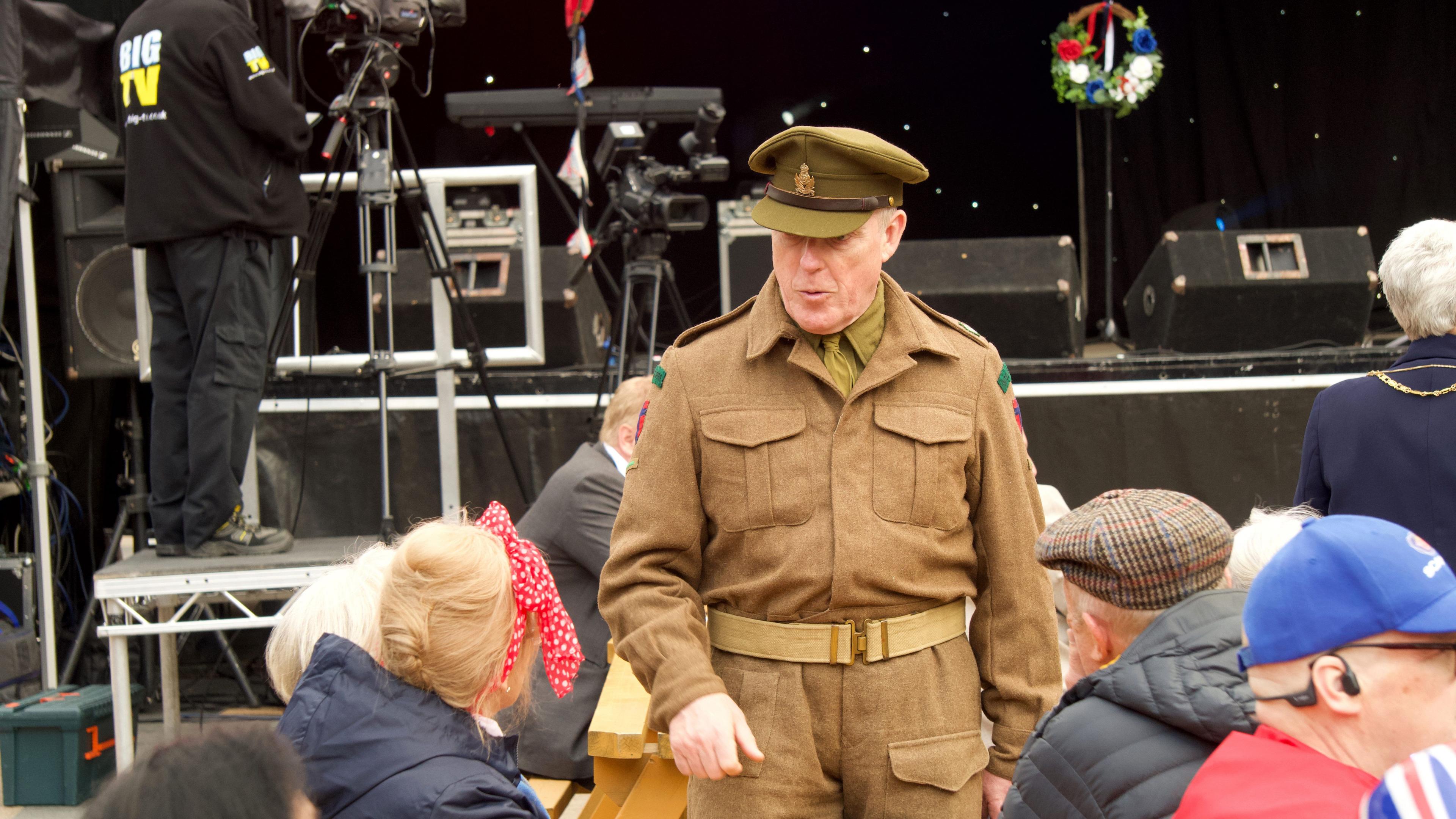 A man dressed in World War Two Army uniform, including an officer's cap