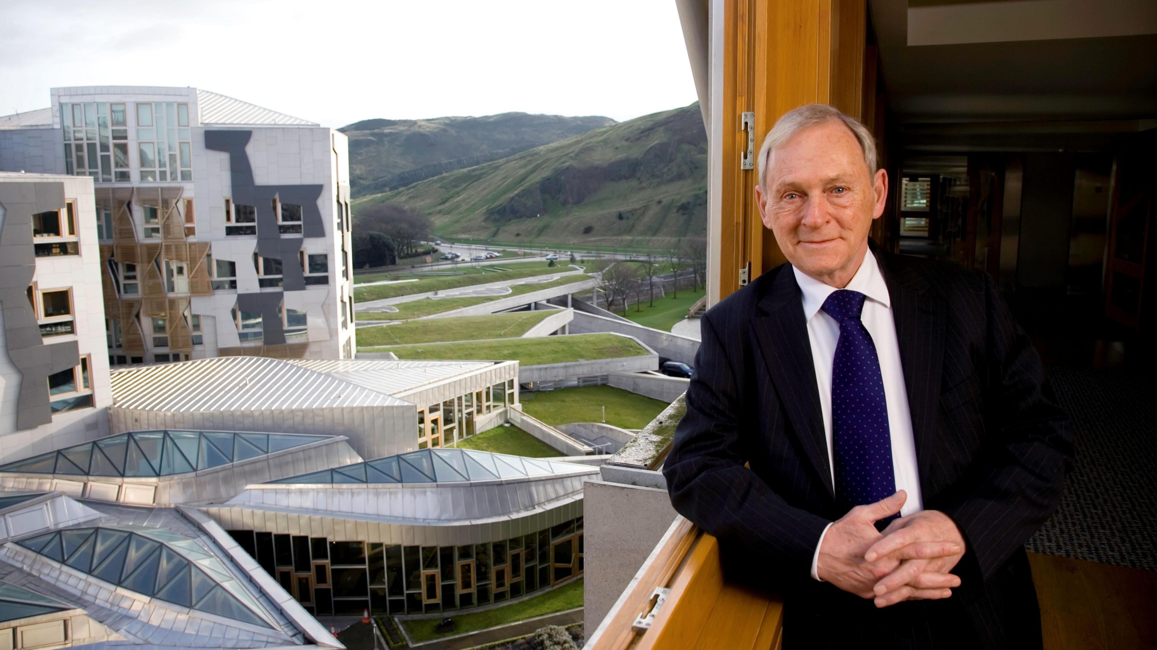 Sir George with the new Holyrood Scottish Parliament building