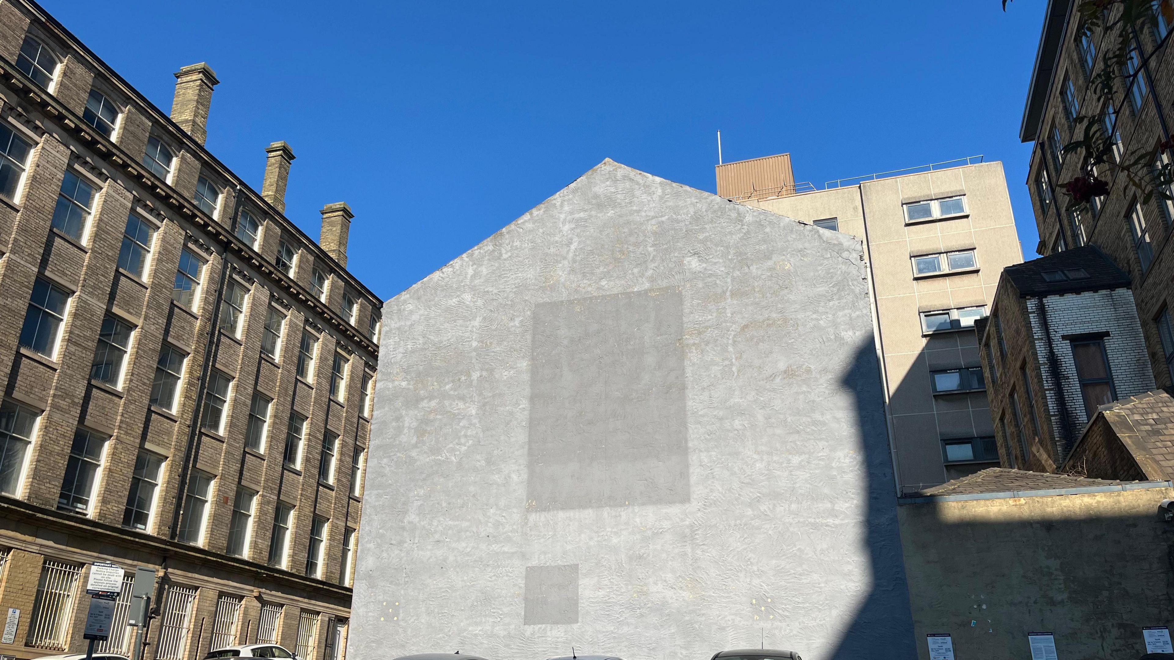 A building with a large square on it where a mural used to be