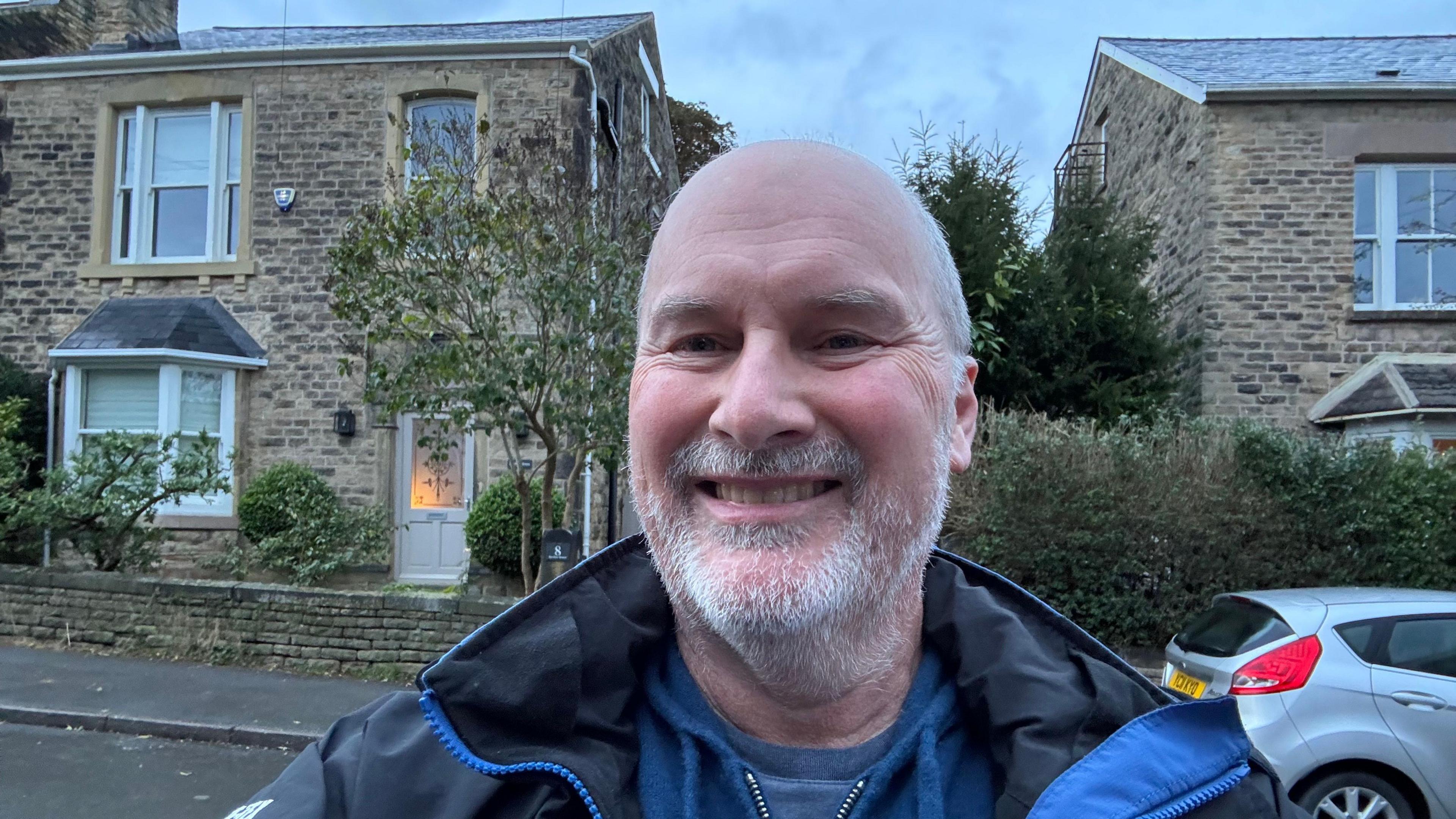 Simon Duffy stands outside his stone-walled house in Sheffield.