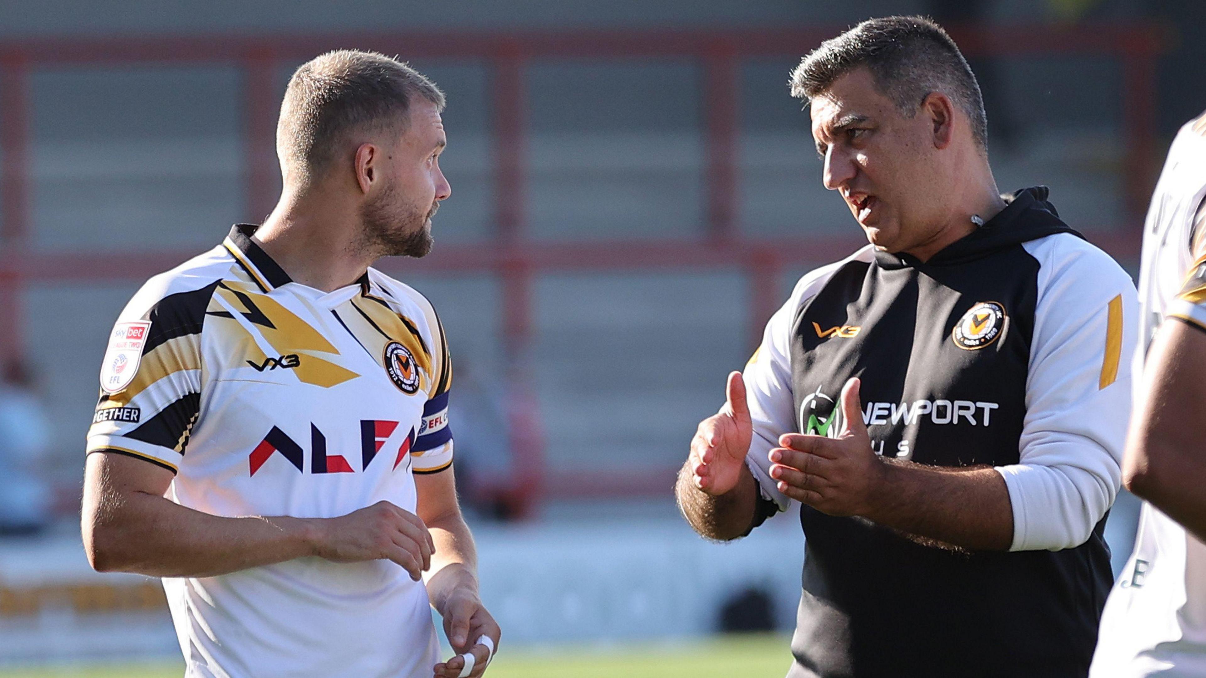 Newport County's Shane McLoughlin in discussion with manager Nelson Jardim after a game