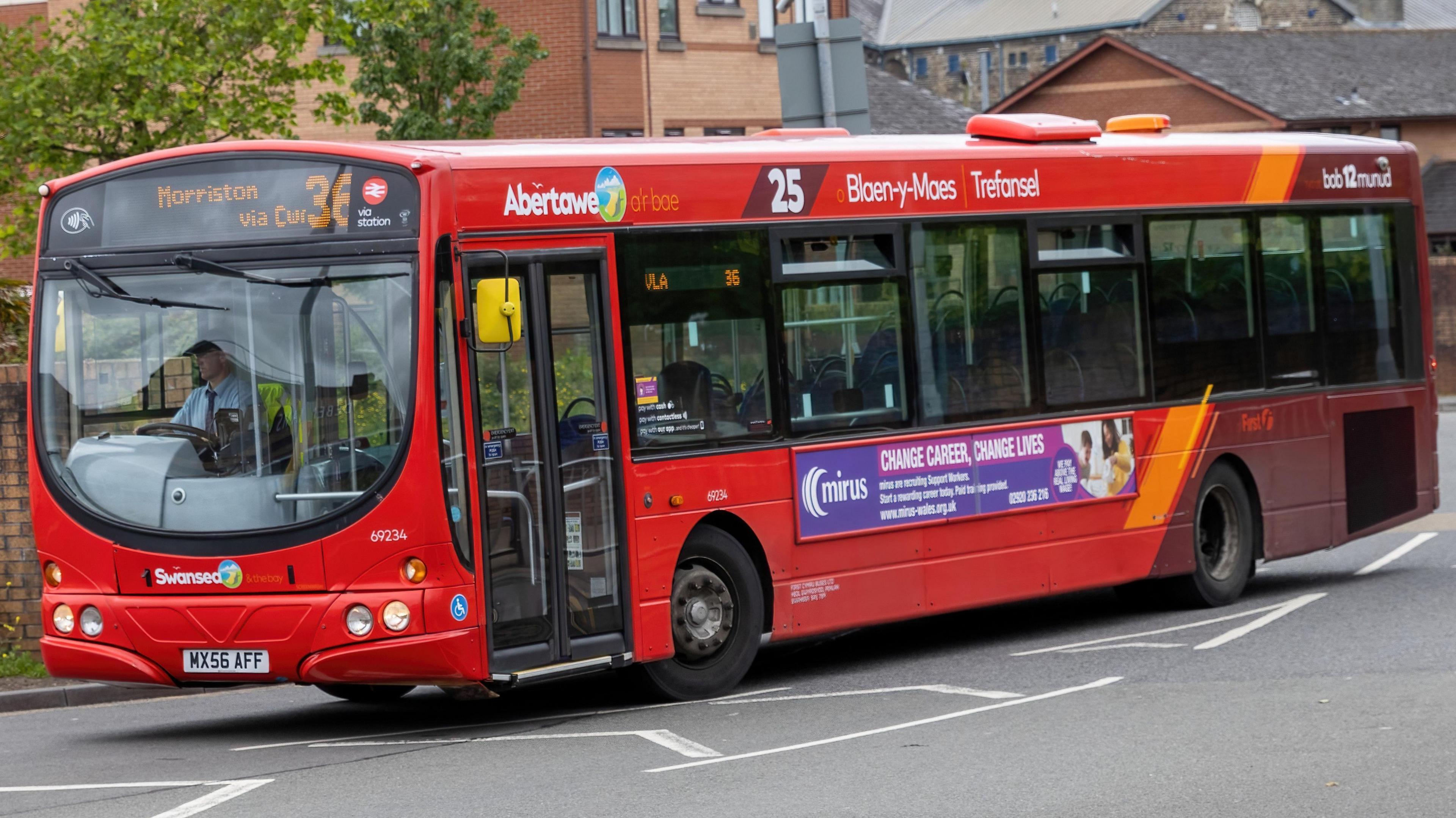 A red bus on a road.