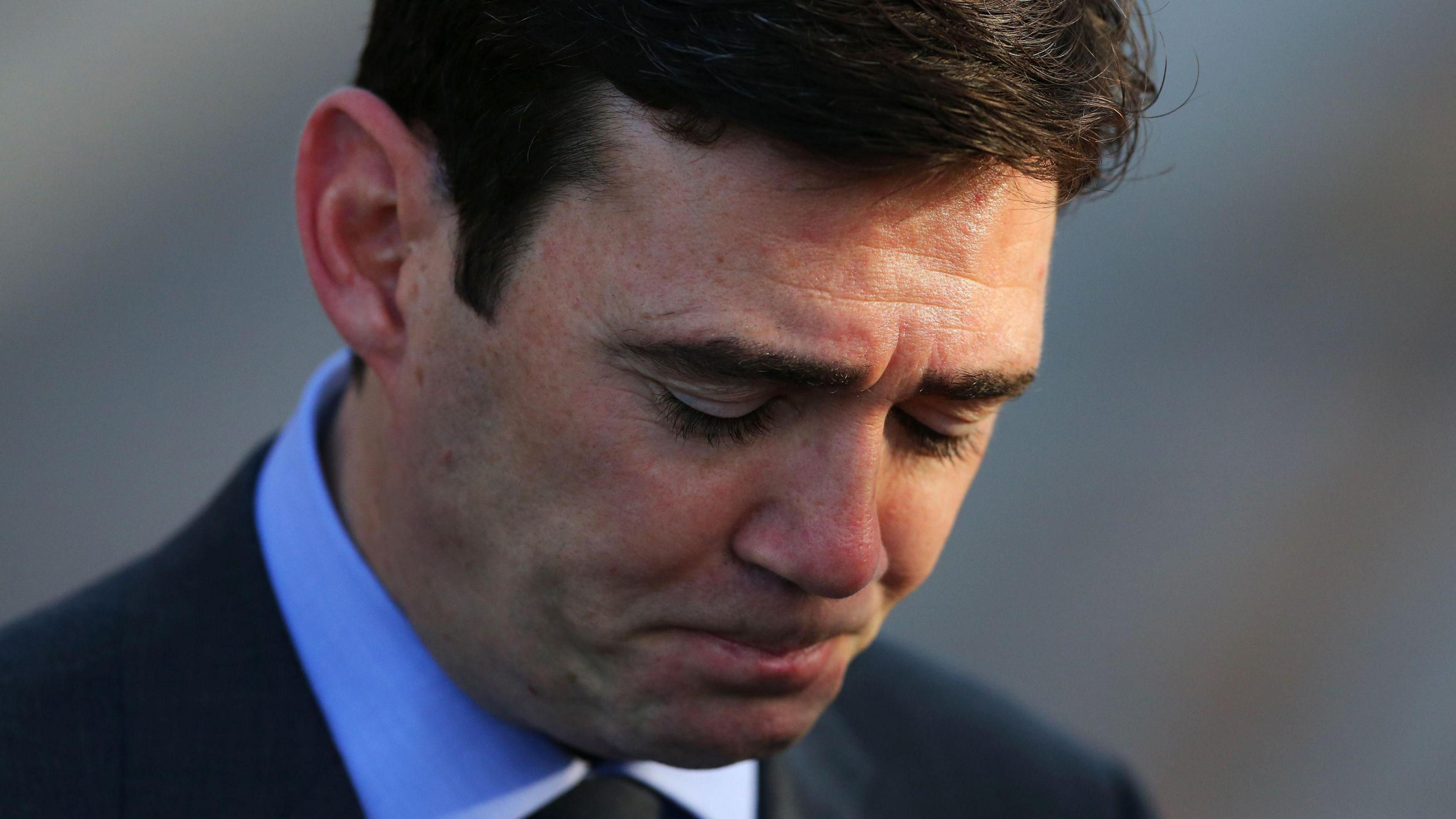 Andy Burnham looking emotional with his head bowed at the funeral of Paul Goggins MP.
