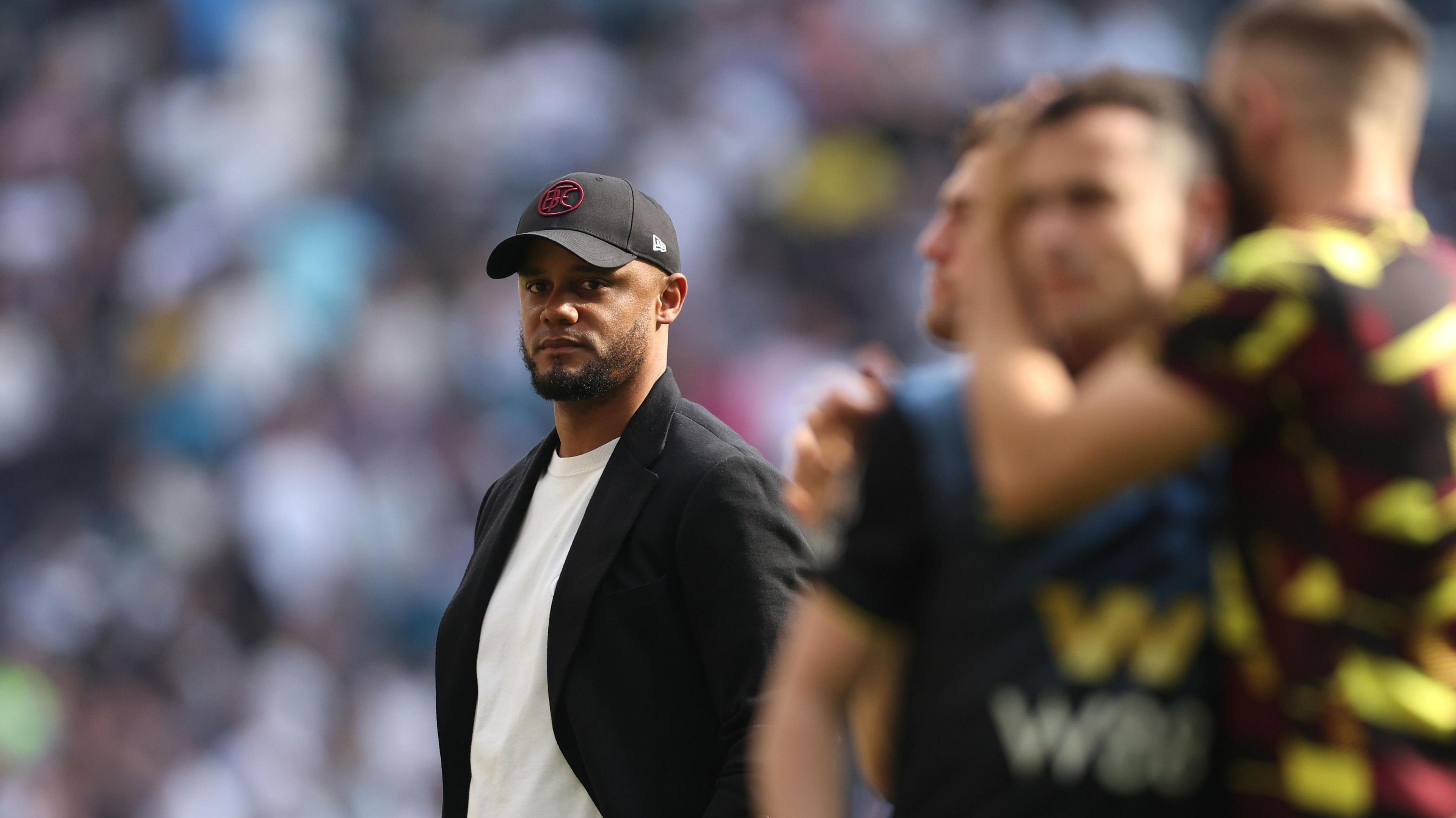 Vincent Kompany watches his Burnley players console each other after relegation