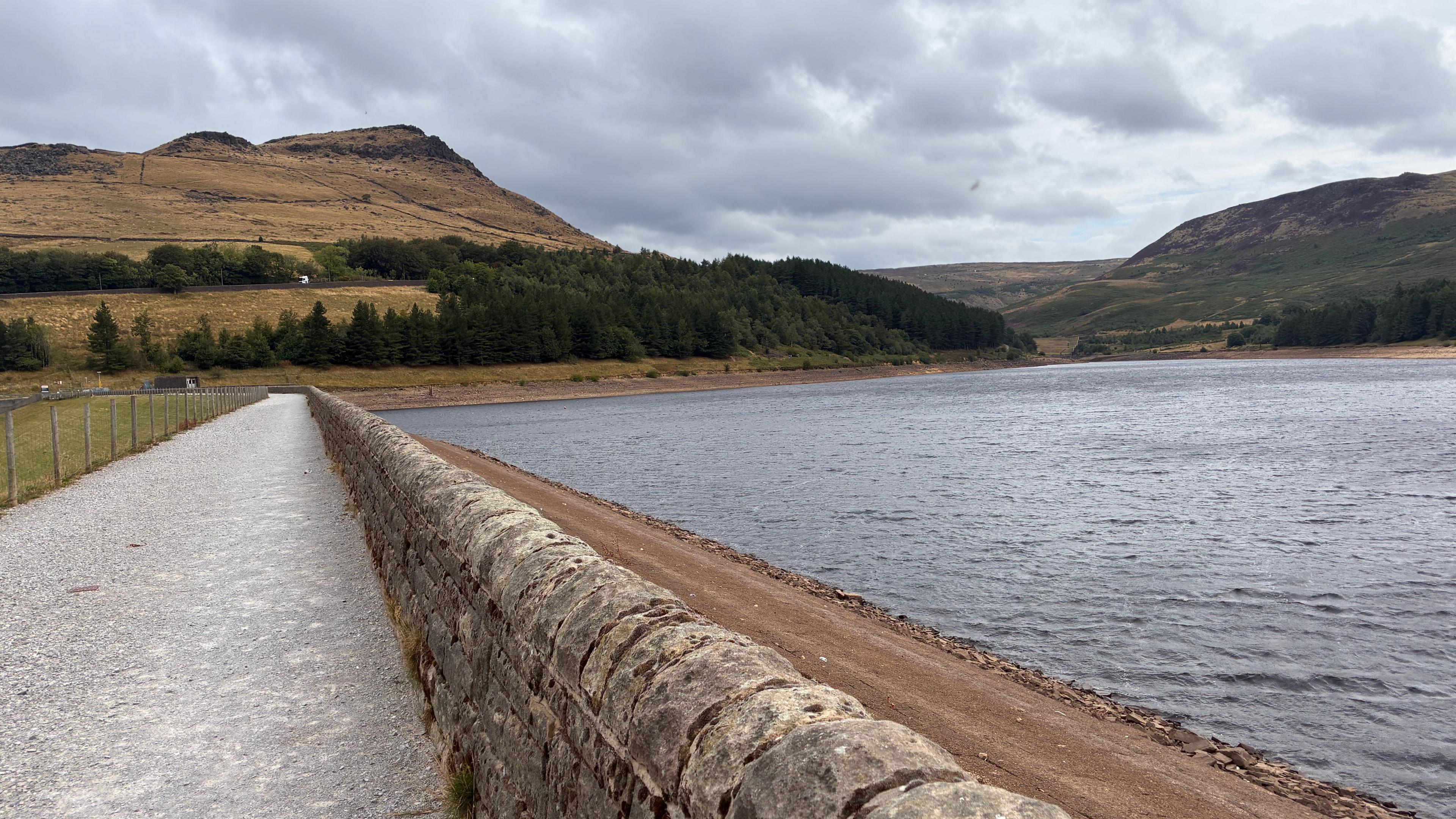A walled concrete pathway with the reservoir to the right