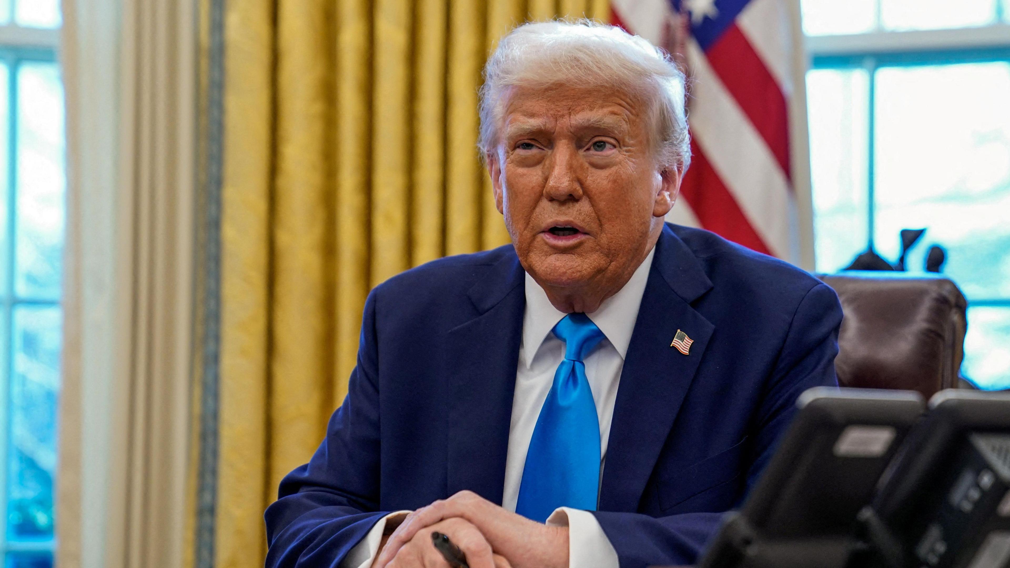 President Donald Trump sits at his desk in the White House 