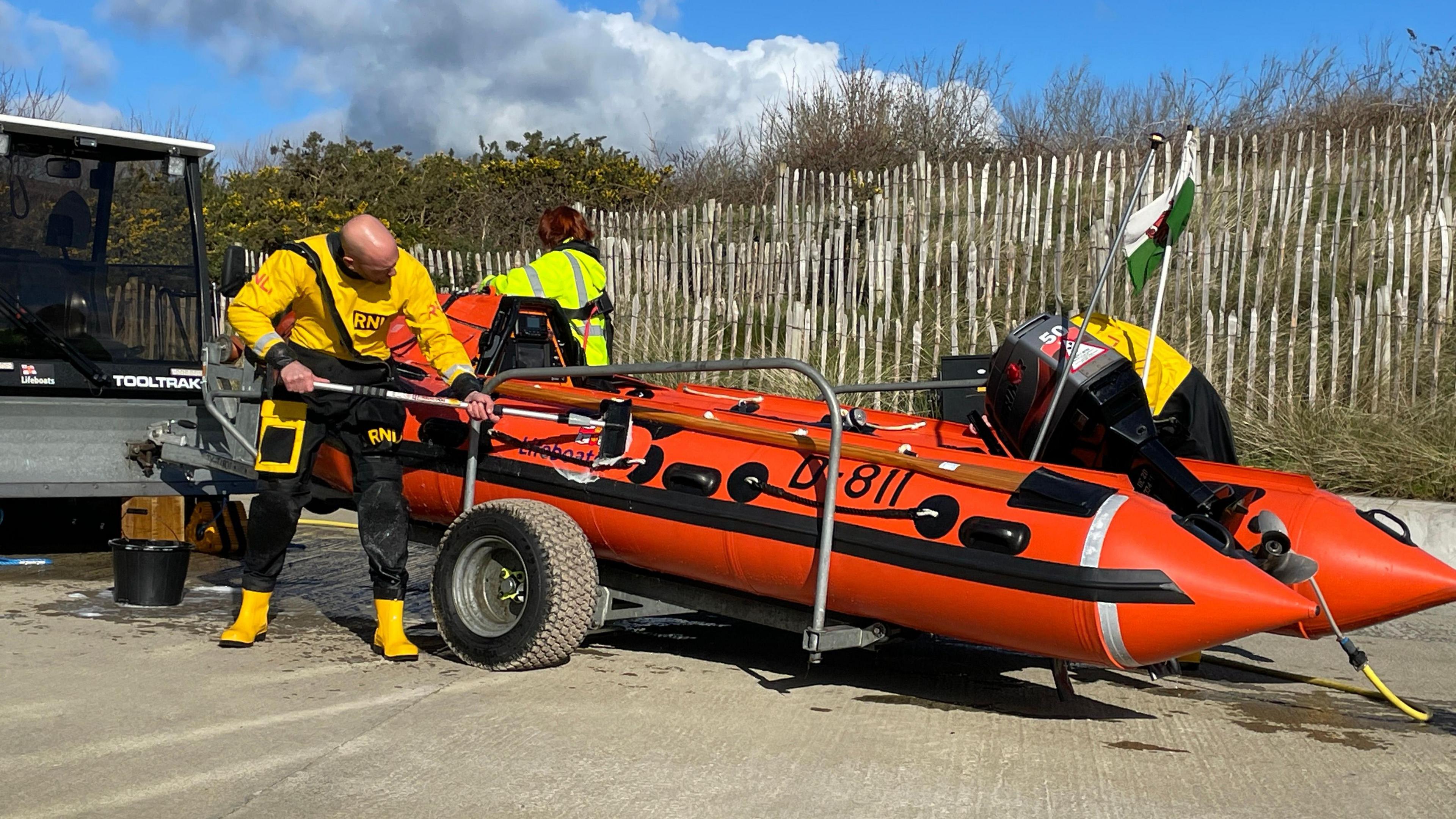 Crew members scub down the inshore D-Class boat