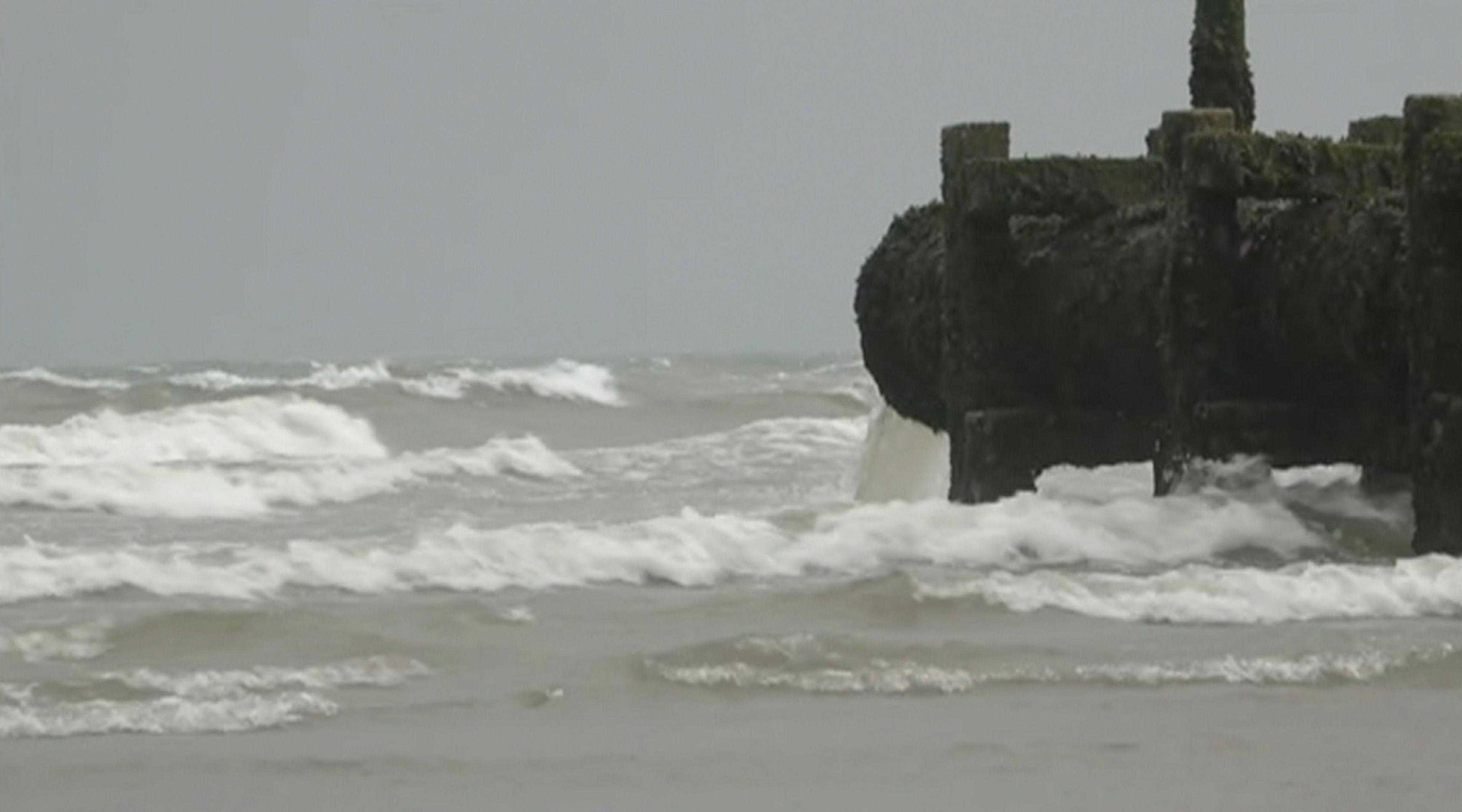 A sewage overflow pipe.. Water can be seen coming out of the pipe and flowing into the sea. 