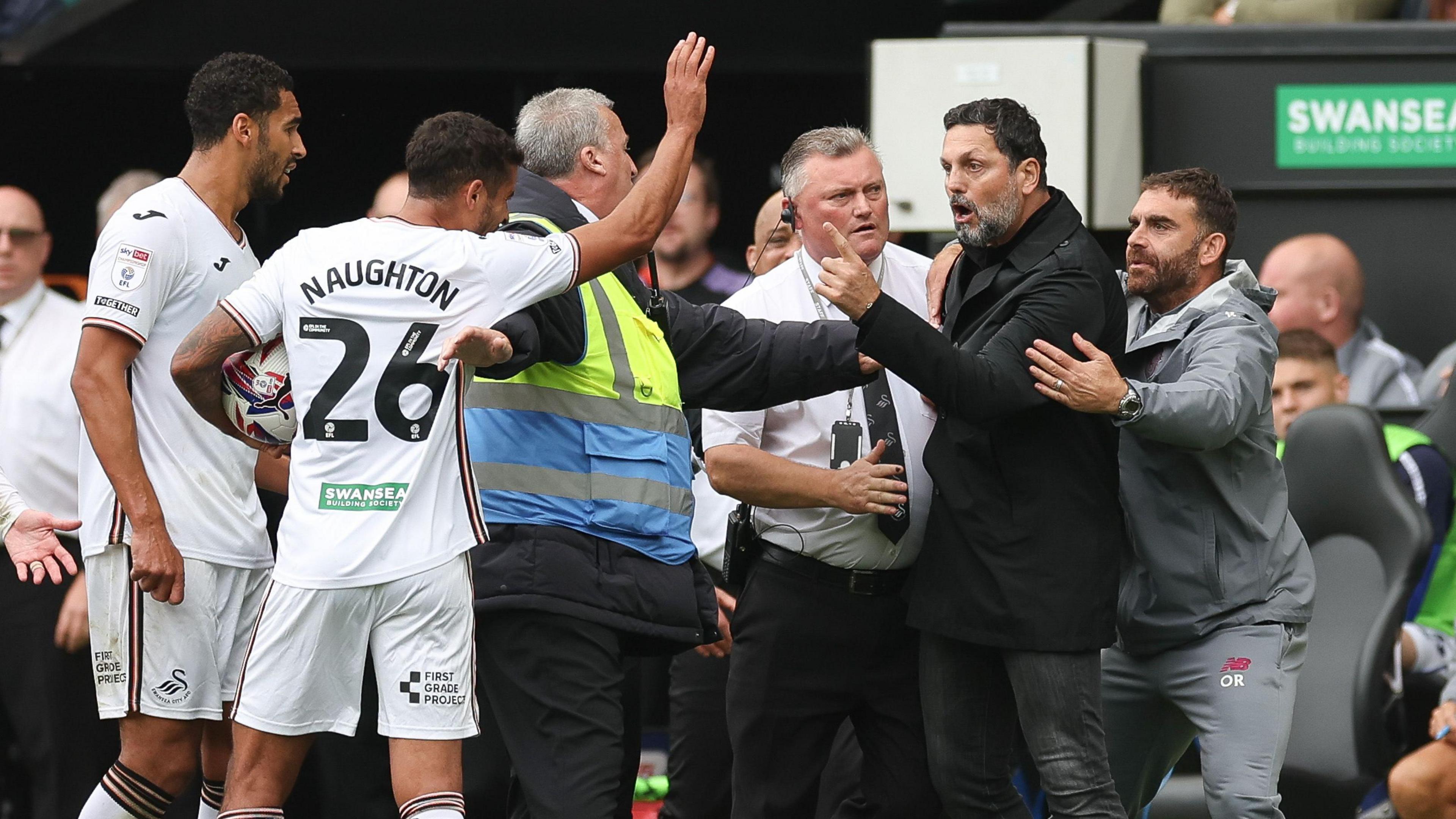 Erol Bulut and Swansea players confront each other during a Championship match