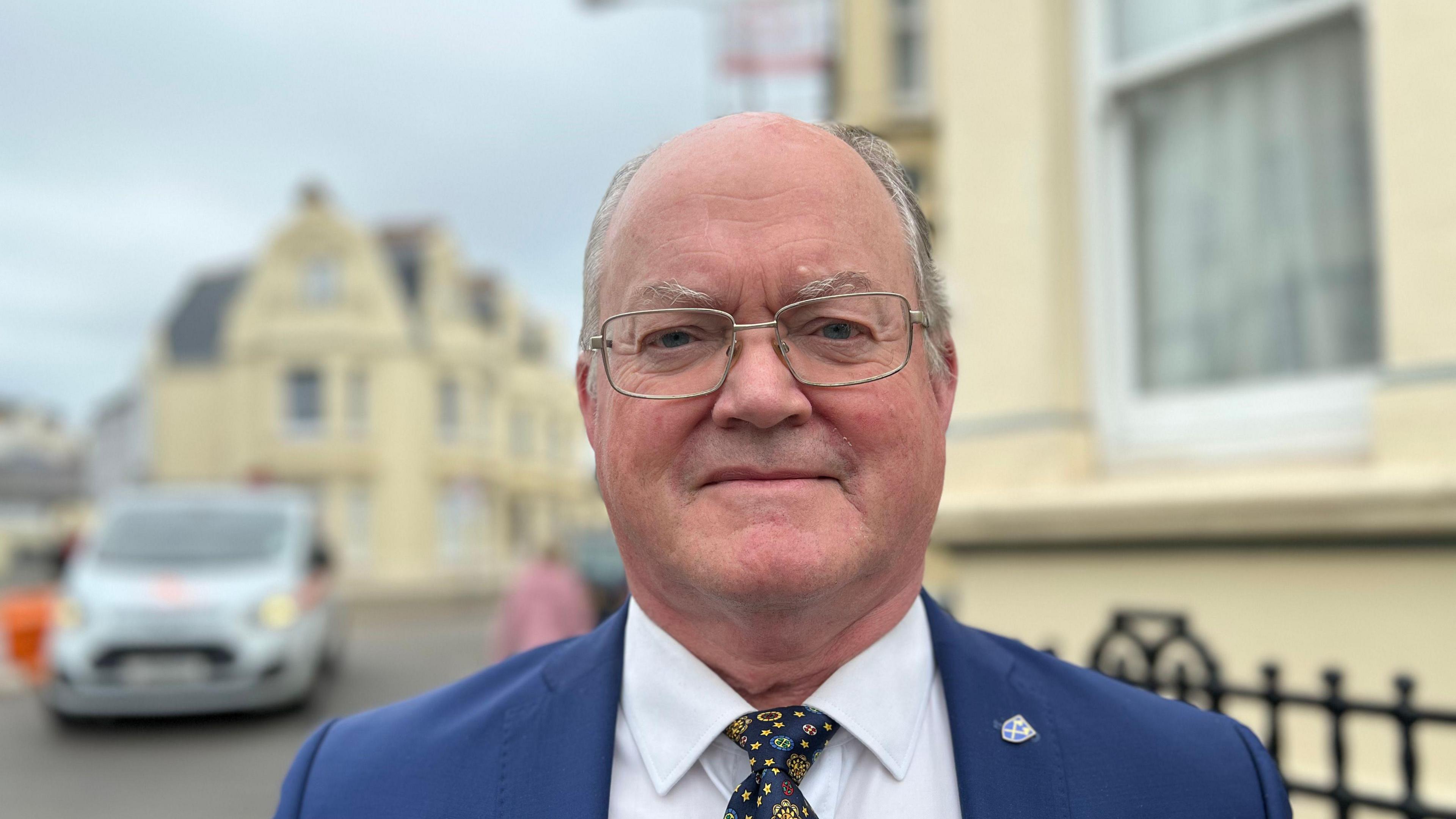 Man in suit standing by the side of a road