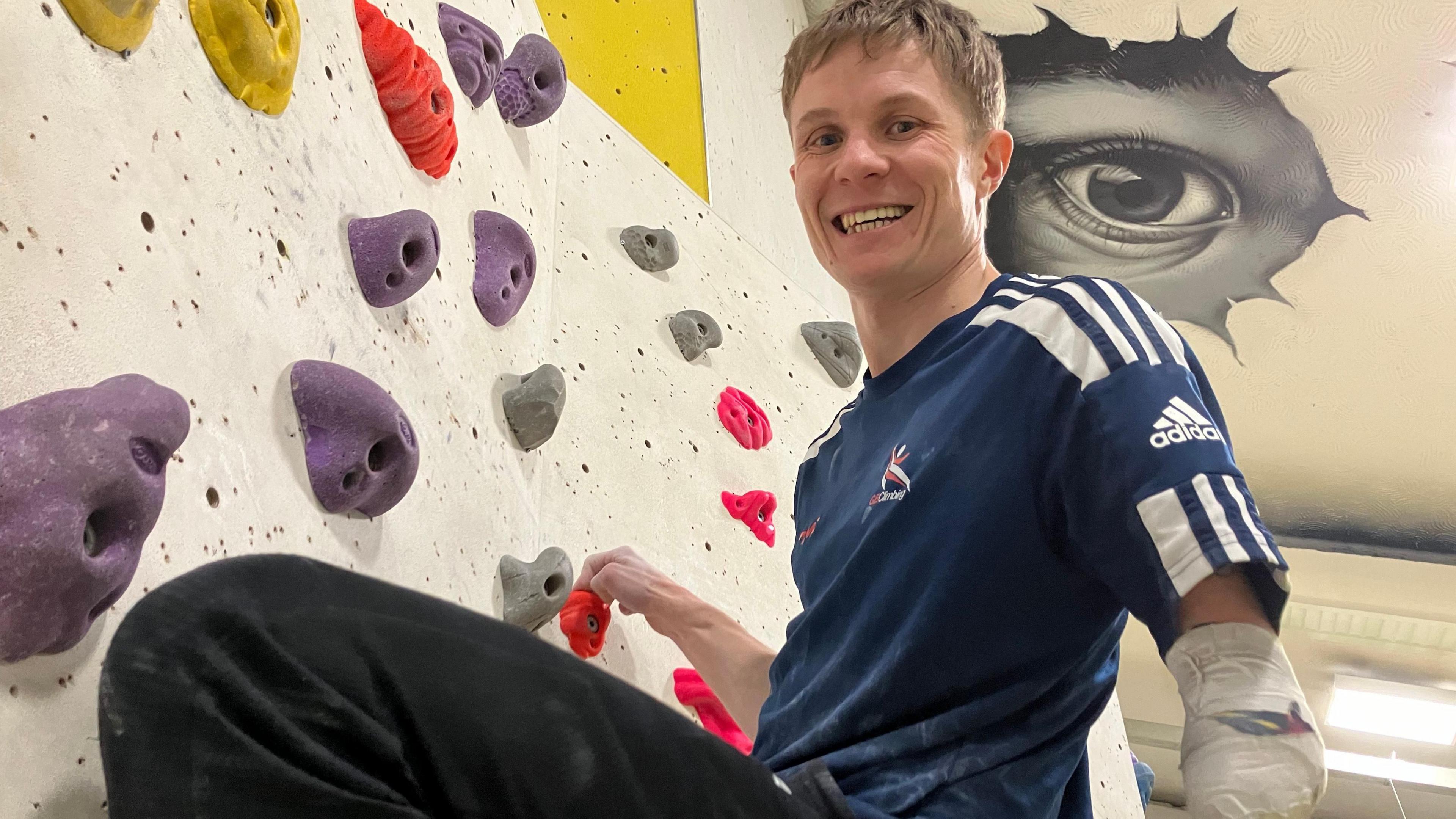paraclimber James half-way up a wall