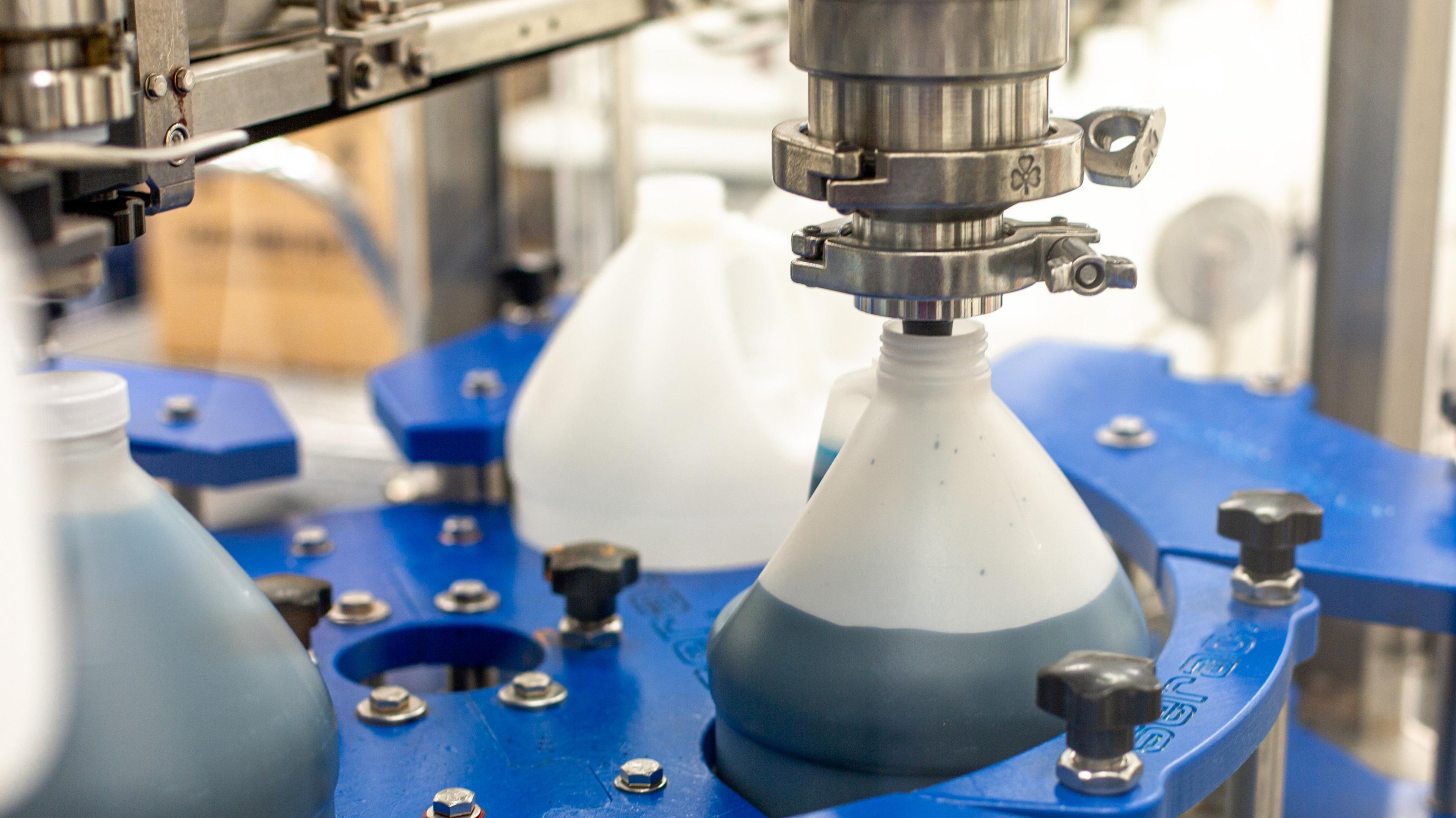 A plastic beaker being filled with a blue dye