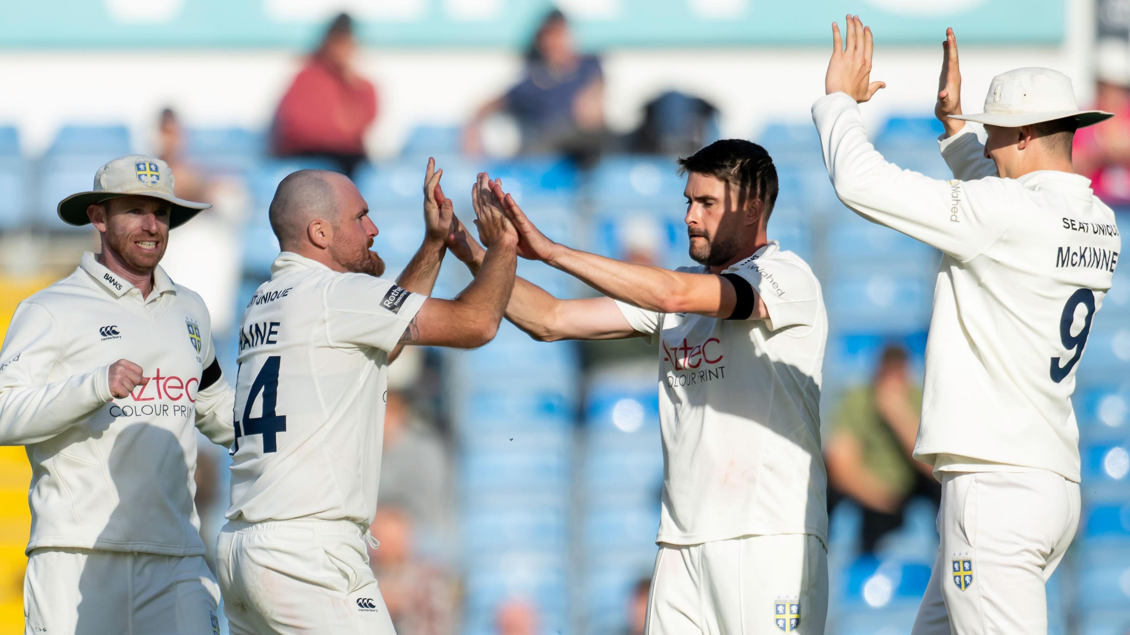 Ben Raine and Will Rhodes high-five each other as two other Durham players run in, including Ben McKinney on the right (McKinney 9 on his back) 