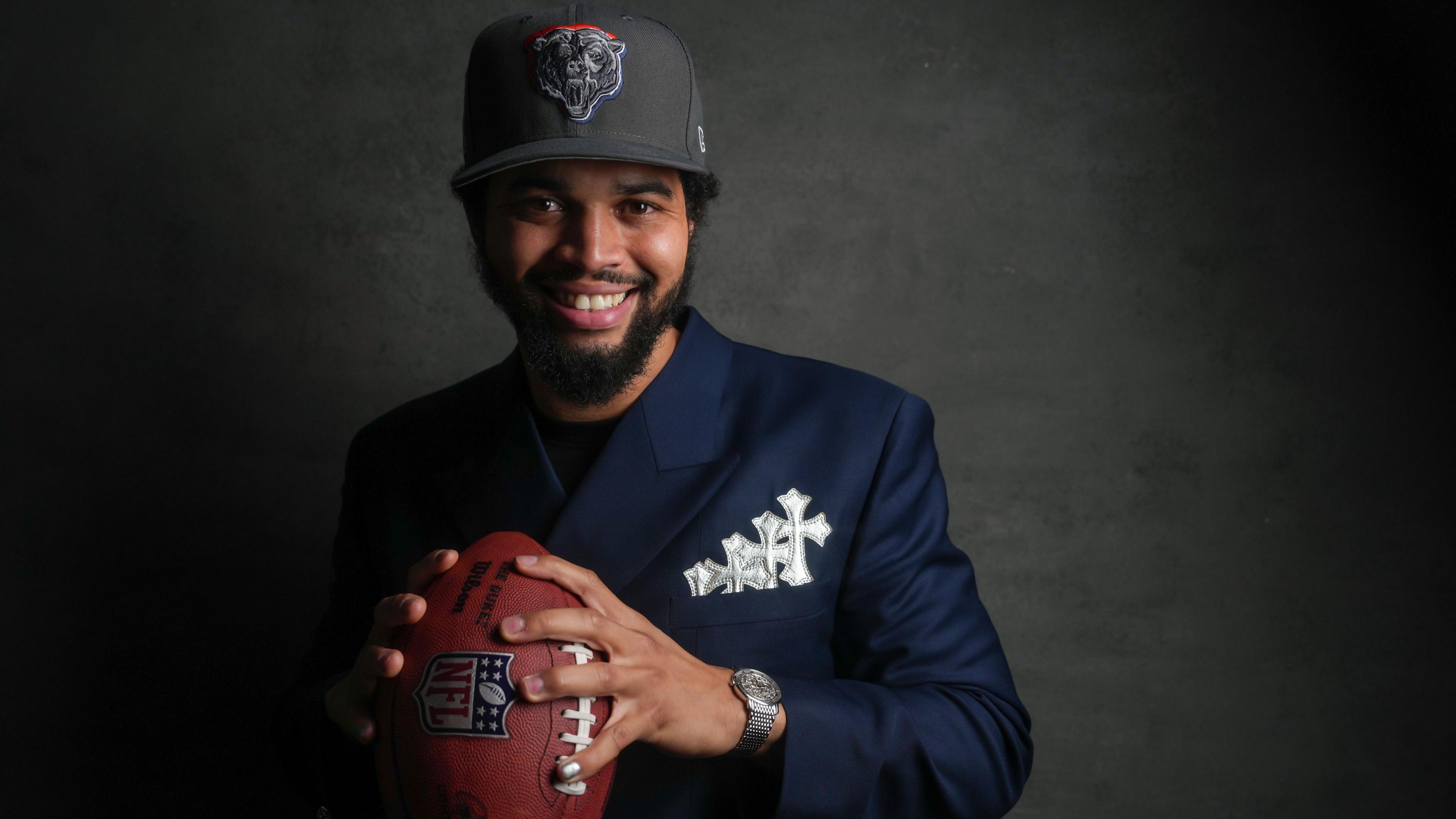 Chicago Bears quarterback Caleb Williams poses with a football