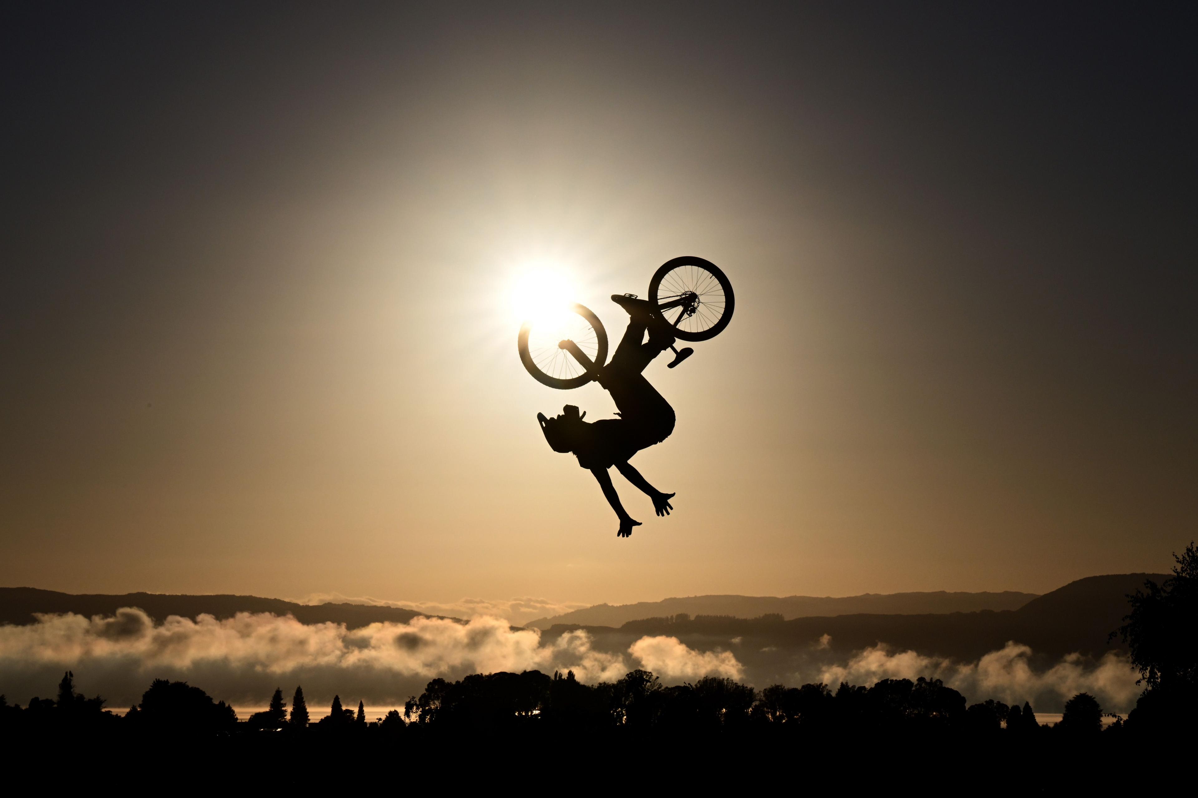 A silhouetted Tim Bringer of France competes in the Maxxis Slopestyle in Memory of McGazza final during Crankworx in Rotorua, New Zealand