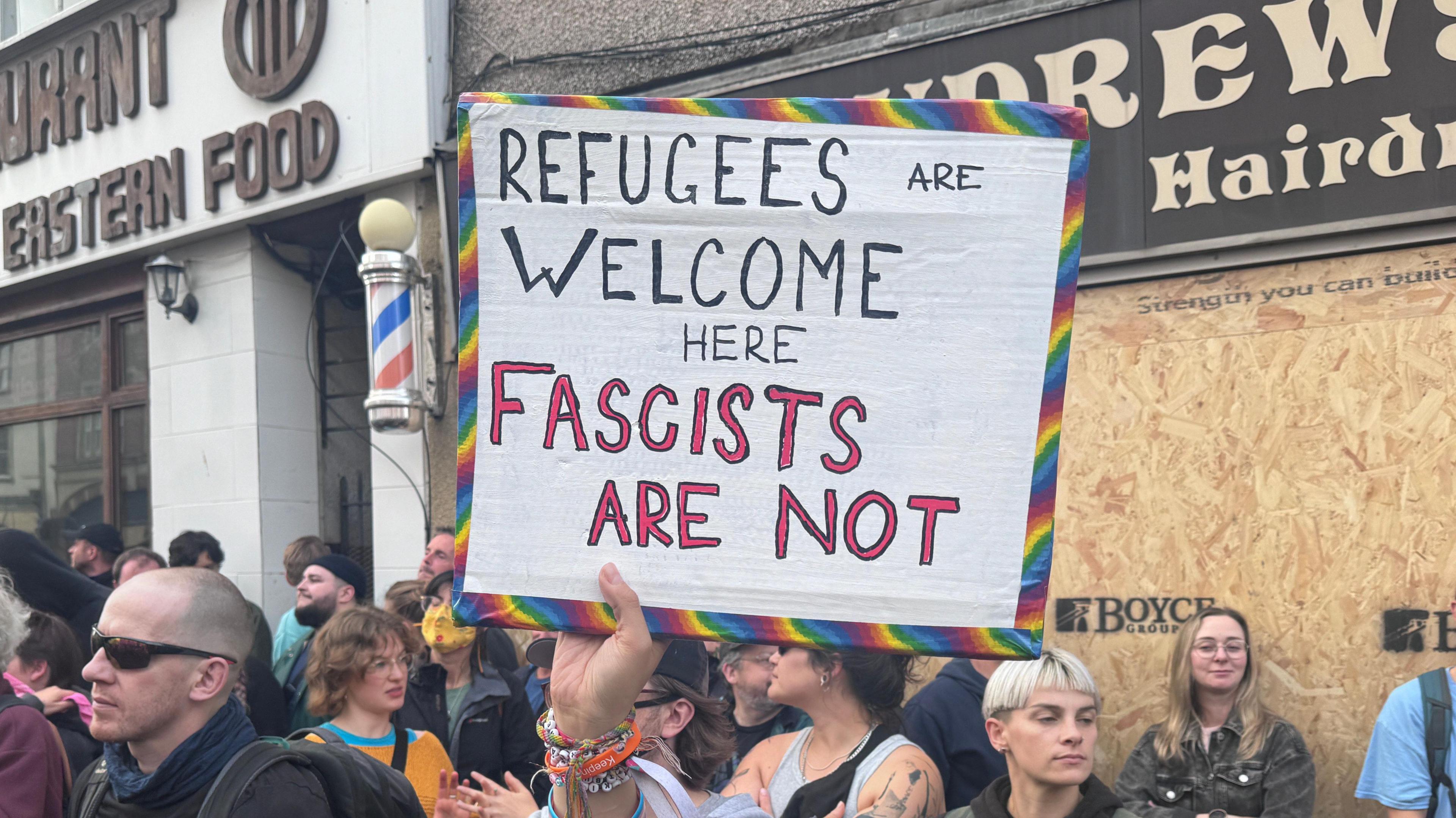 Sign reading "refugees are welcome here fascists are not"