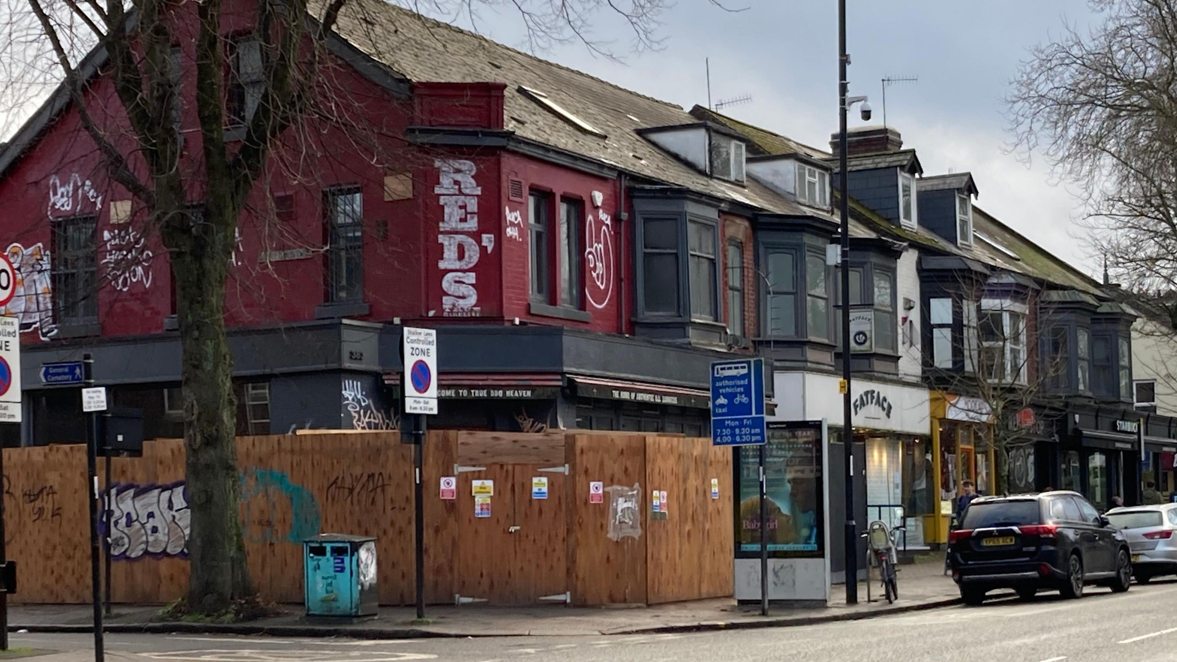 A shop on Ecclesall Road with boards around it