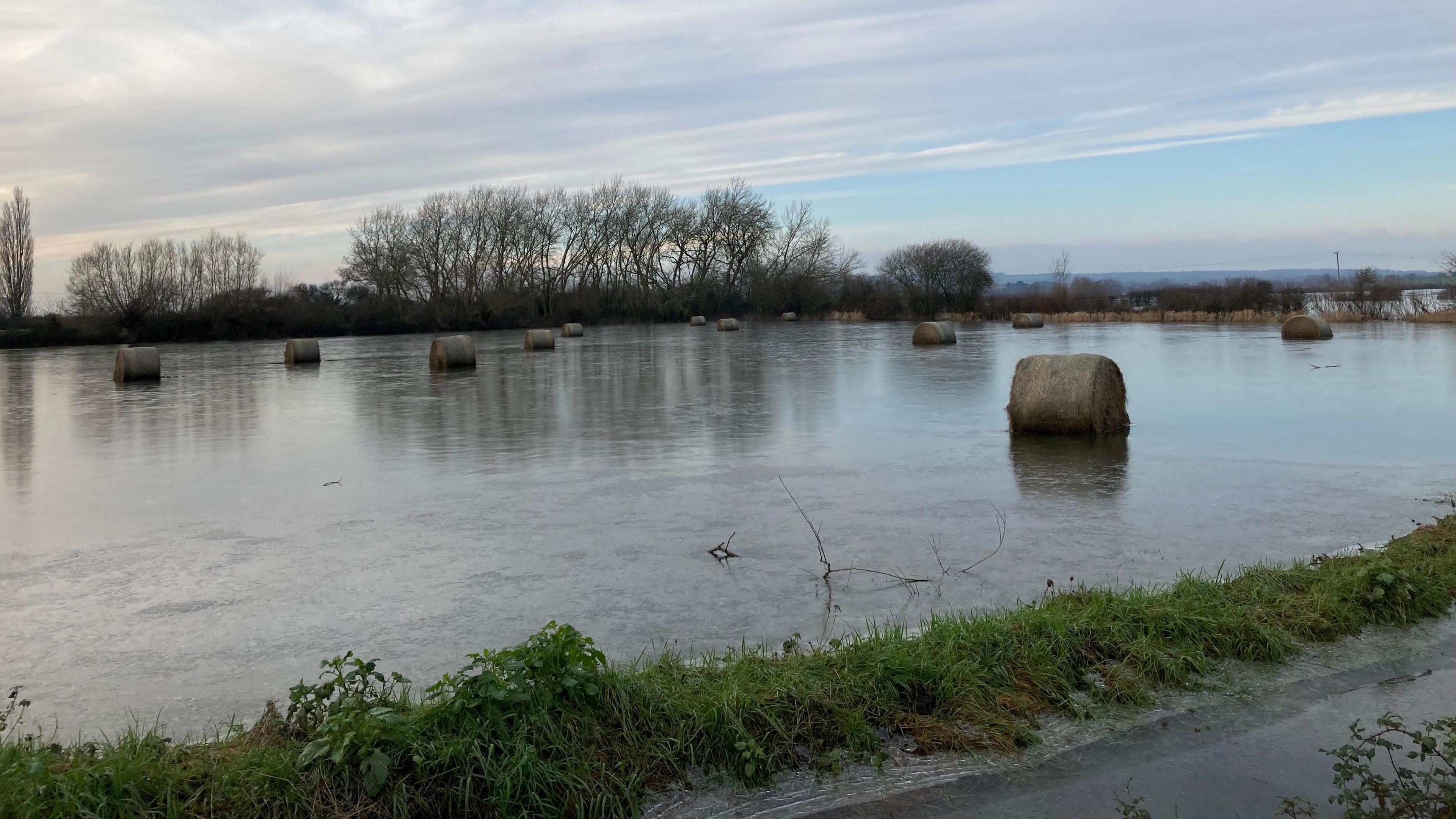 A flooded field on the Somerset Levels, with hay bales in the water