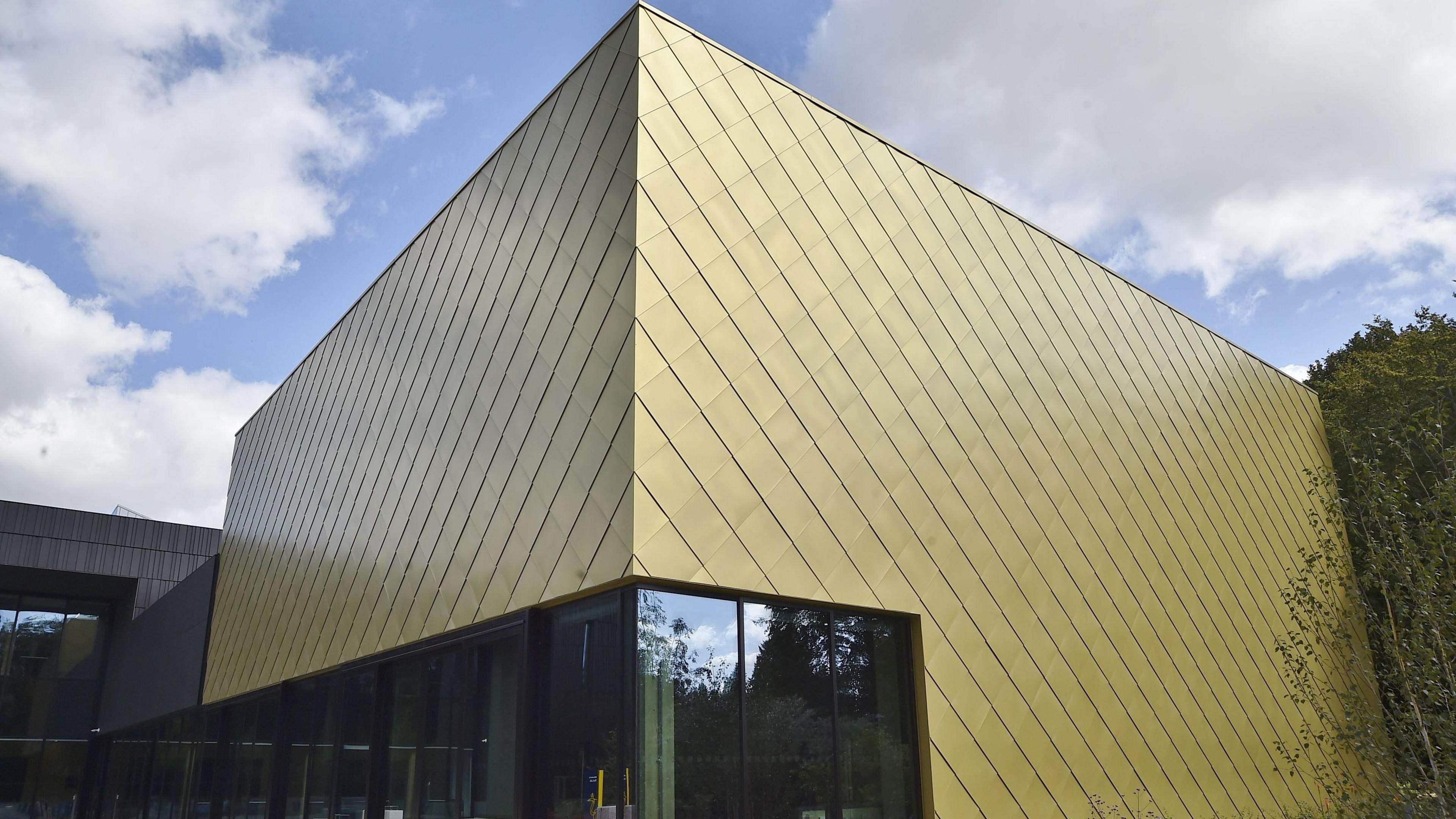 Part of ARU Peterborough's new lab - a futuristic square-shaped building with gold tiles.