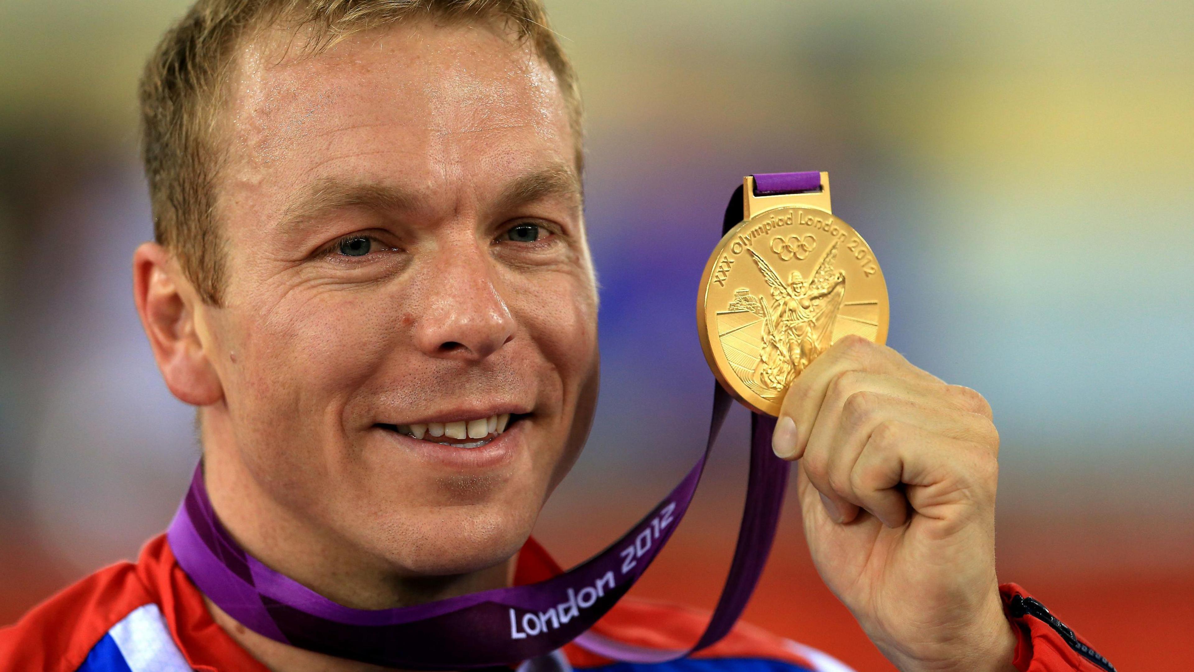 Sir Chris Hoy celebrating winning in the Men's Keirin at the London 2012 Olympics, holding up his gold medal.
