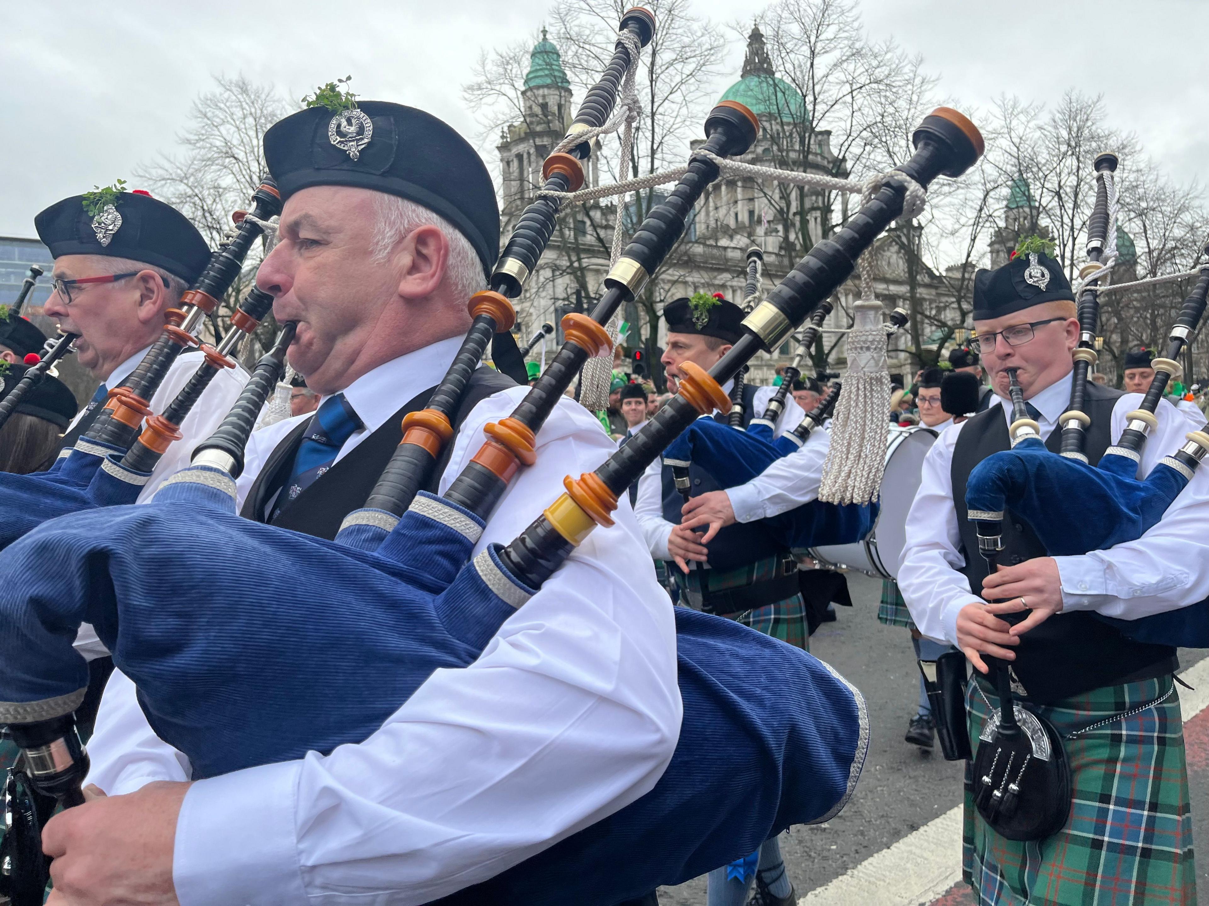 men with bagpipes walking past belfast city hall